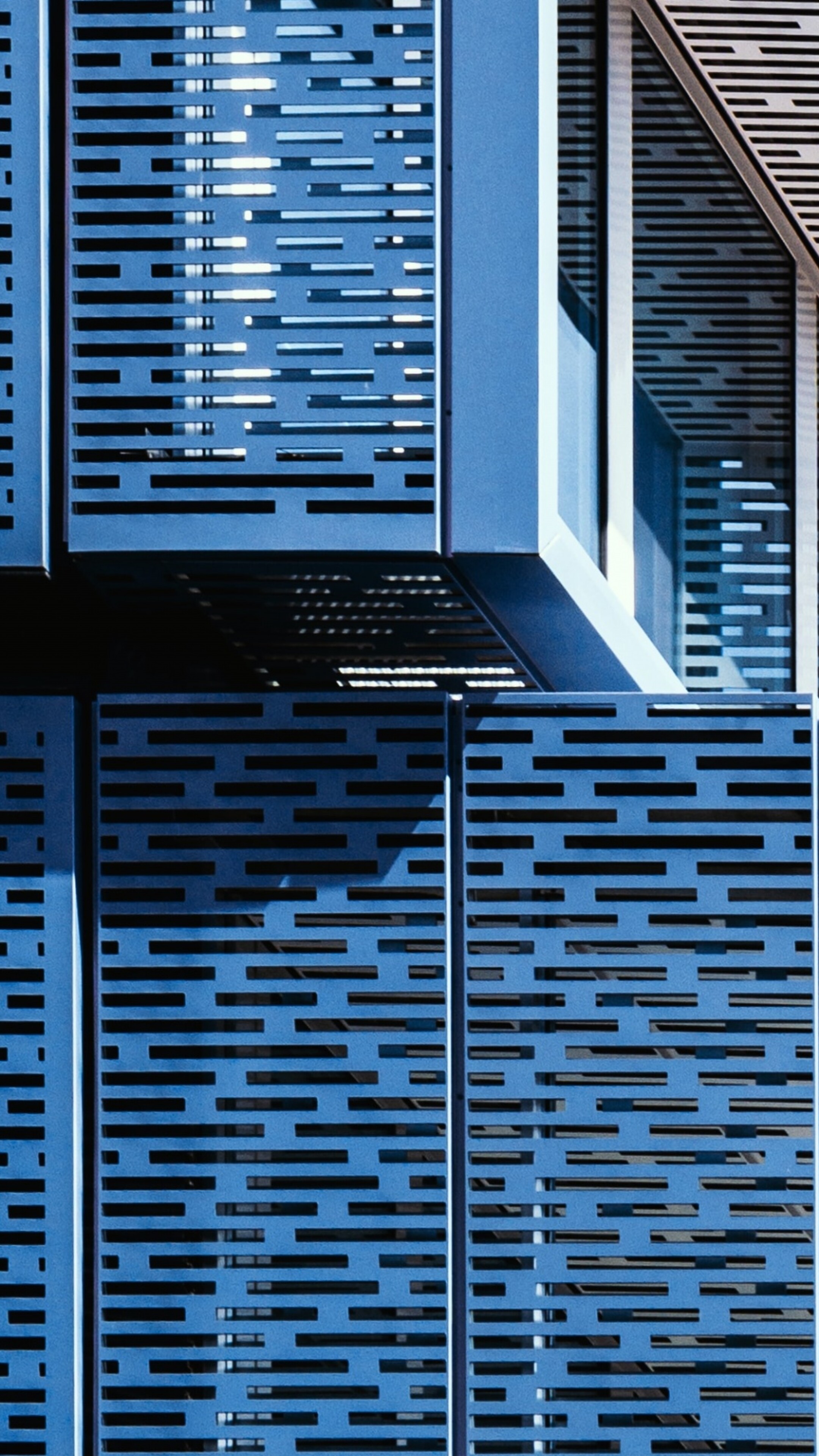 A symmetrical blue building featuring complex geometric patterns and modern architectural design.