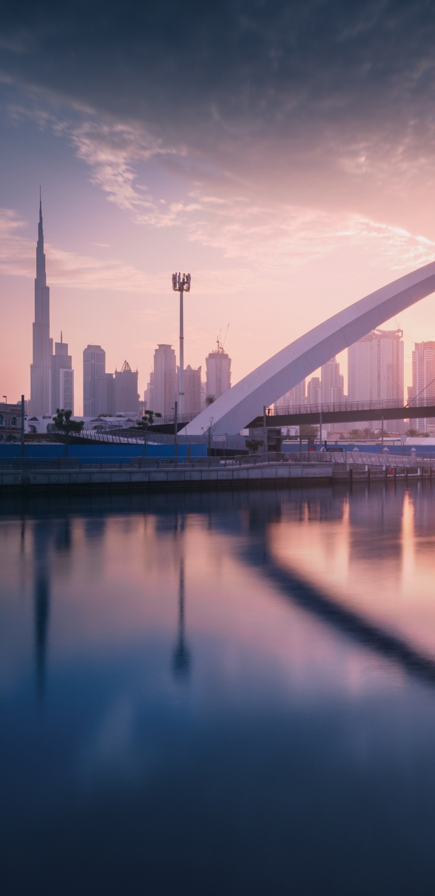 A panoramic view of the Dubai skyline at sunset with modern skyscrapers and waterfront views.