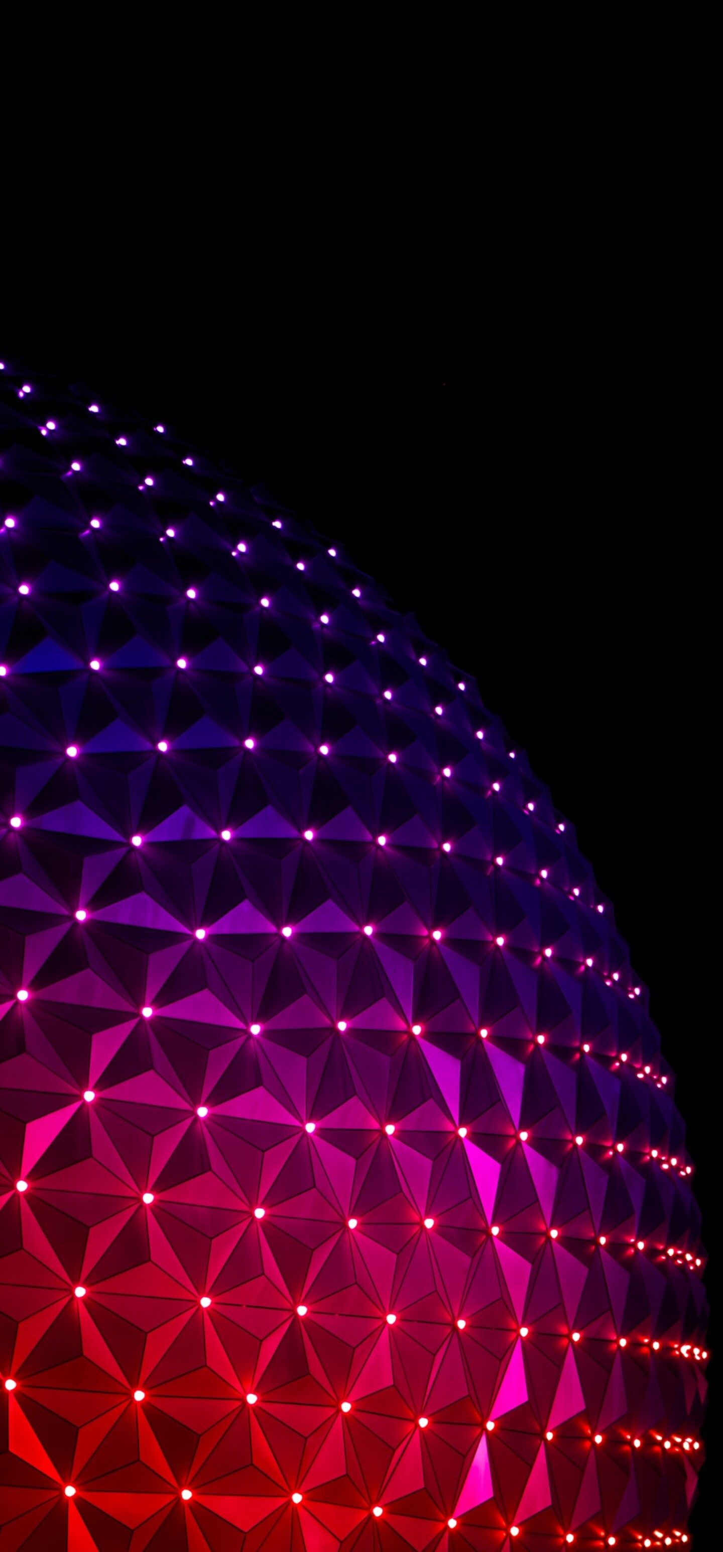 The glowing Spaceship Earth structure at Epcot, Walt Disney World, captured at night with a black background.