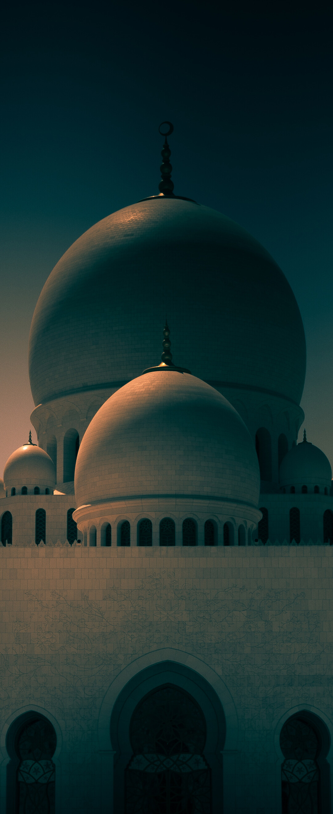 The stunning white marble architecture of the Sheikh Zayed Grand Mosque in Abu Dhabi, UAE, under a clear sky.