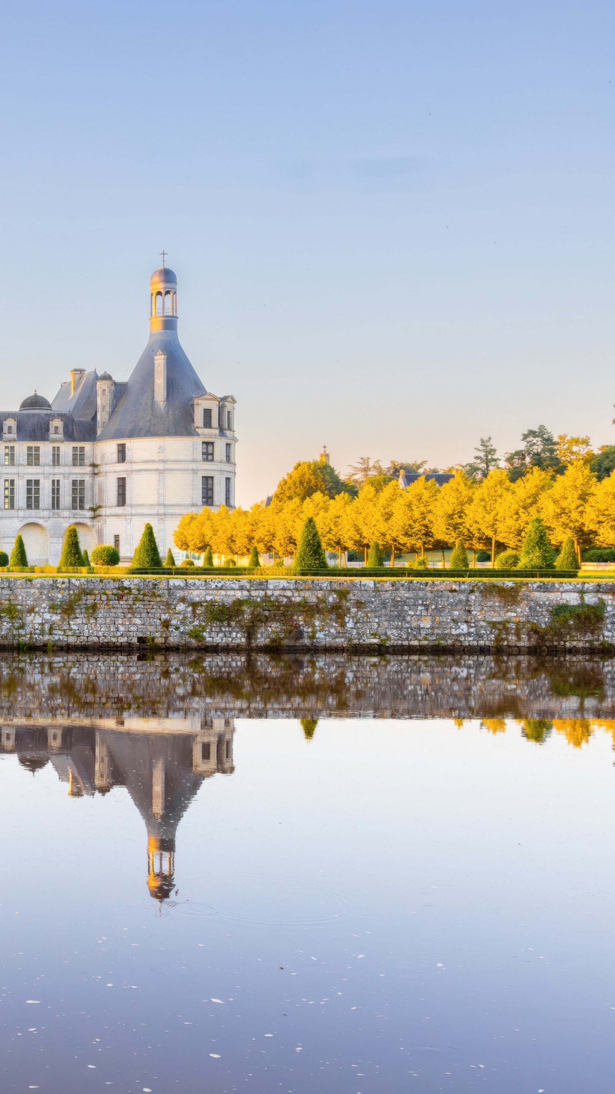 Sunlight reflecting off ancient stone buildings in France during a clear daytime.