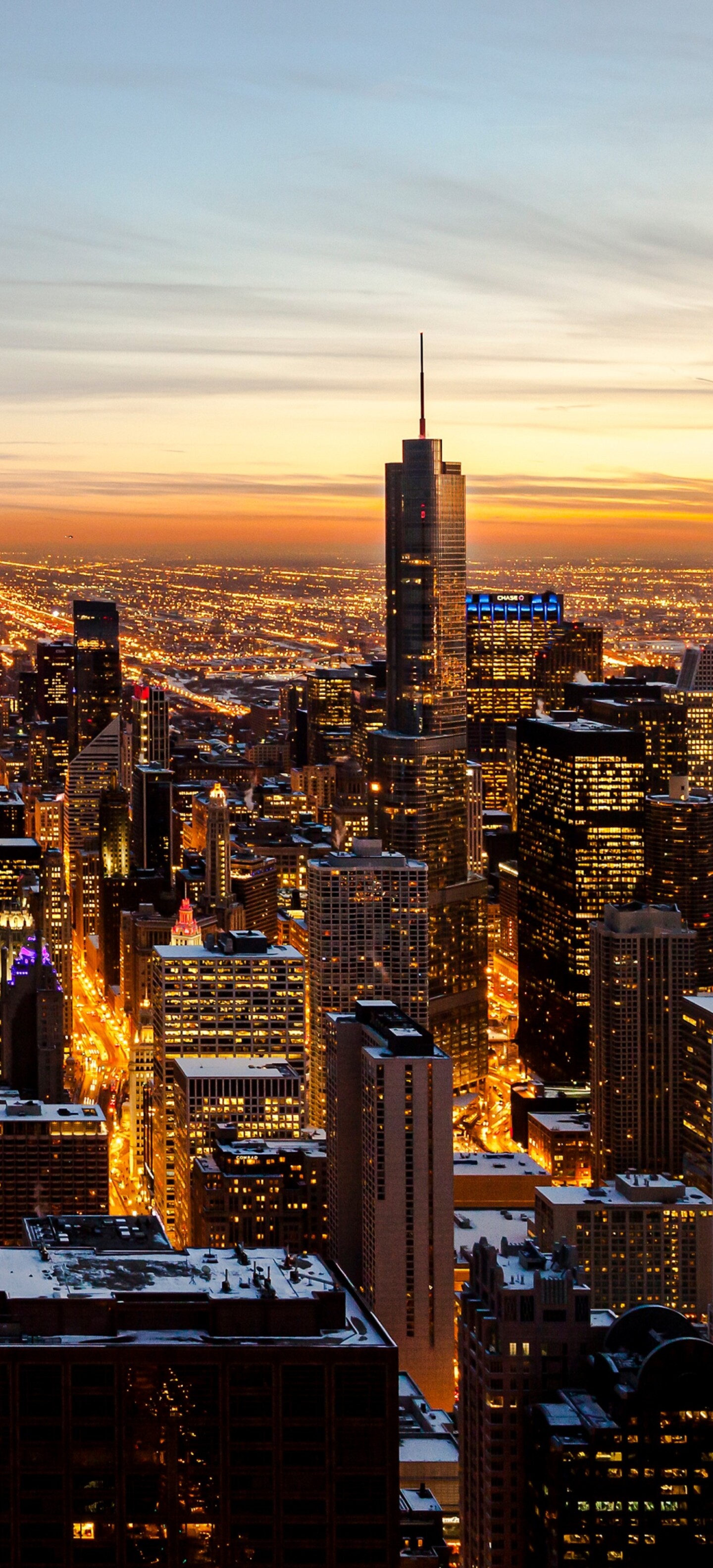 Aerial photography of the Chicago downtown skyline featuring skyscrapers under a colorful sunset sky at dusk.