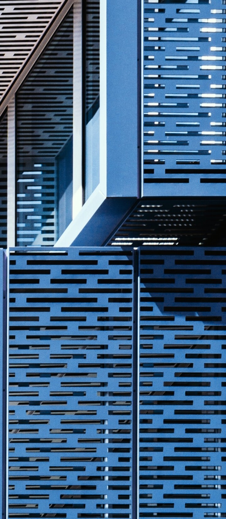 A symmetrical blue building facade with intricate geometric patterns and modern architectural design.