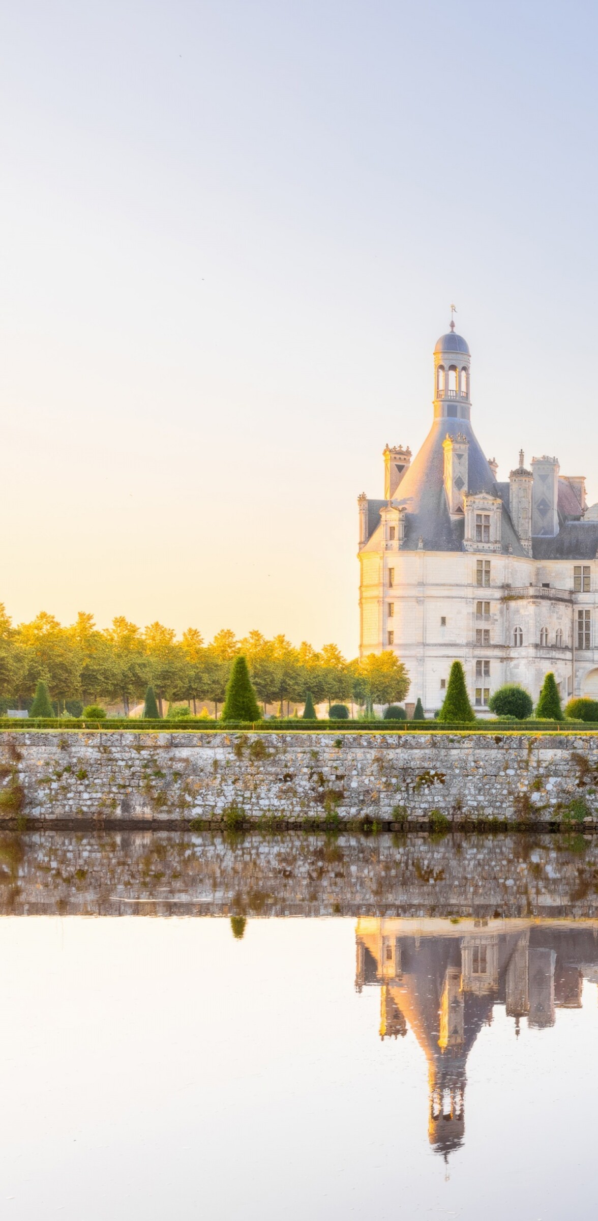 Sunlight reflecting on ancient stone buildings and classical architecture in France during the daytime.