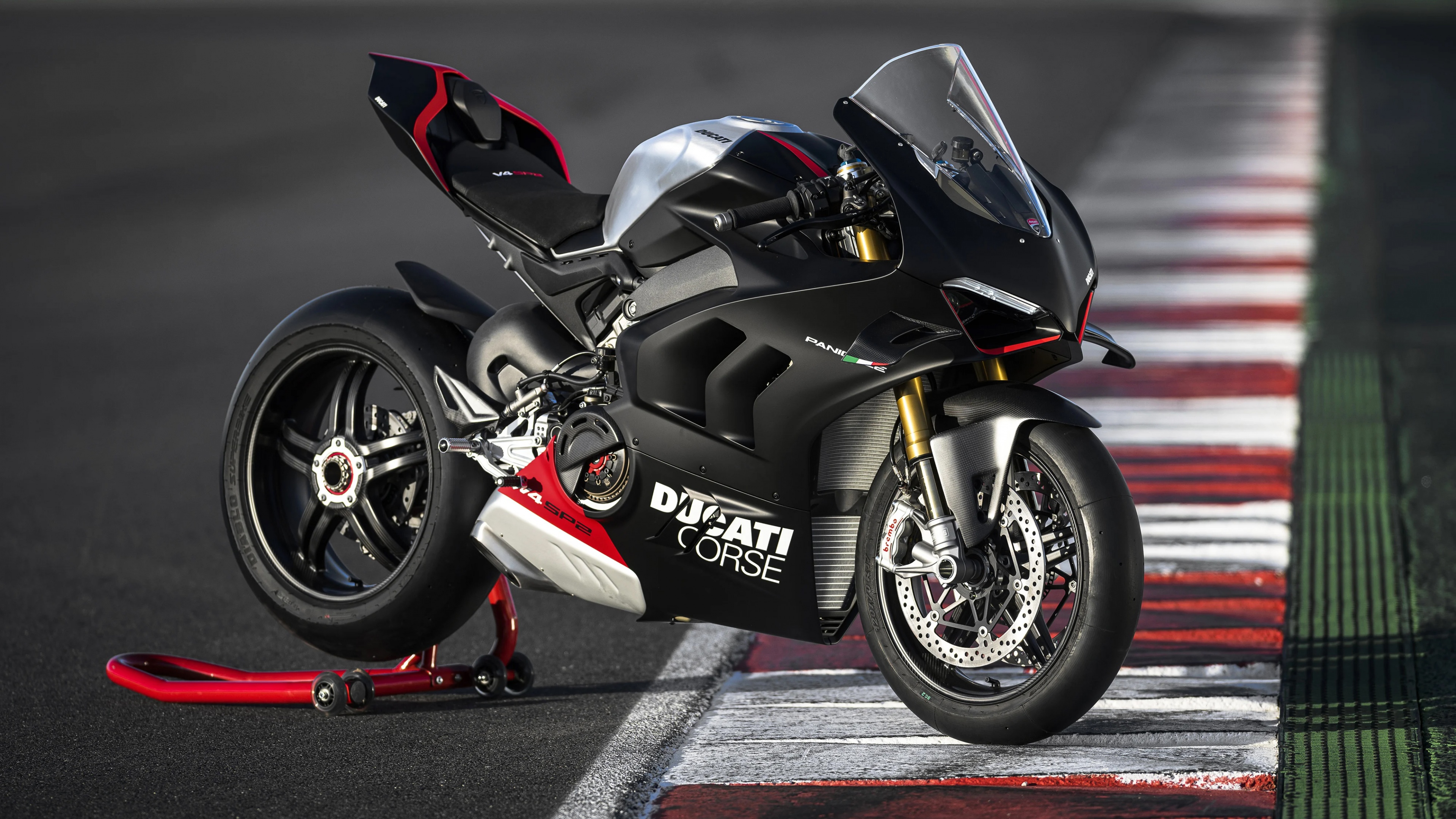A 2023 Ducati Panigale V4 SP2 sports motorcycle parked on a professional race track.