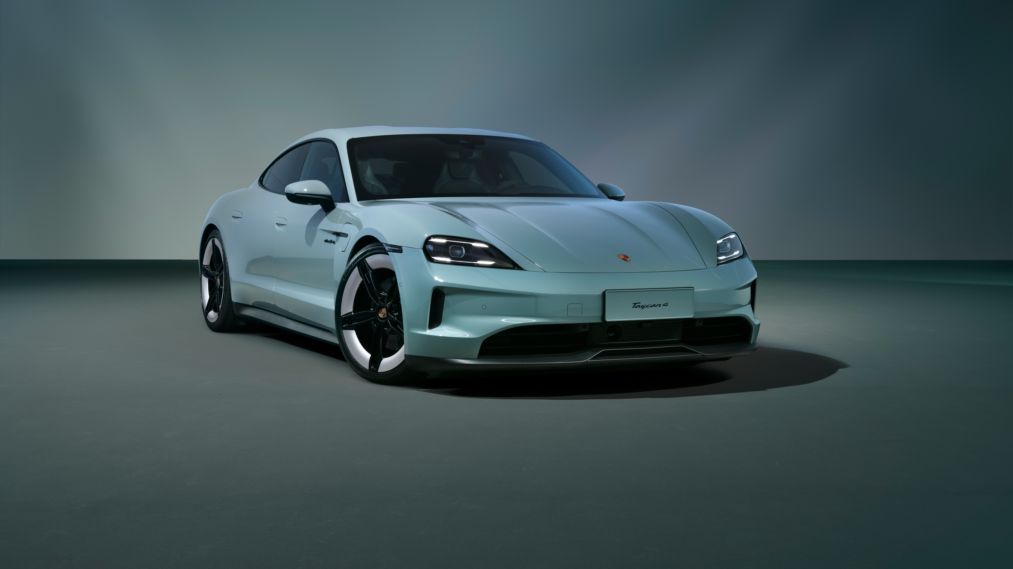 A high-resolution, detailed shot of a 2024 Porsche Taycan electric sports car showcasing its sleek aerodynamic design.