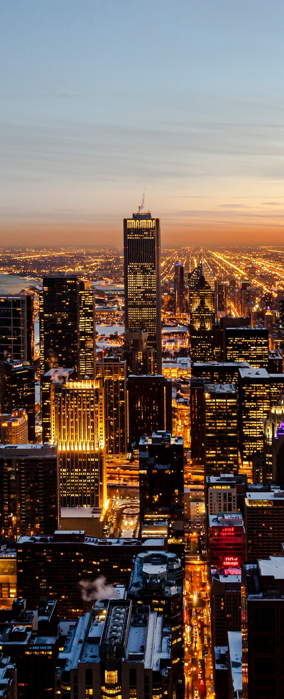 Aerial view of the Chicago downtown skyline and skyscrapers under a vibrant sunset sky.