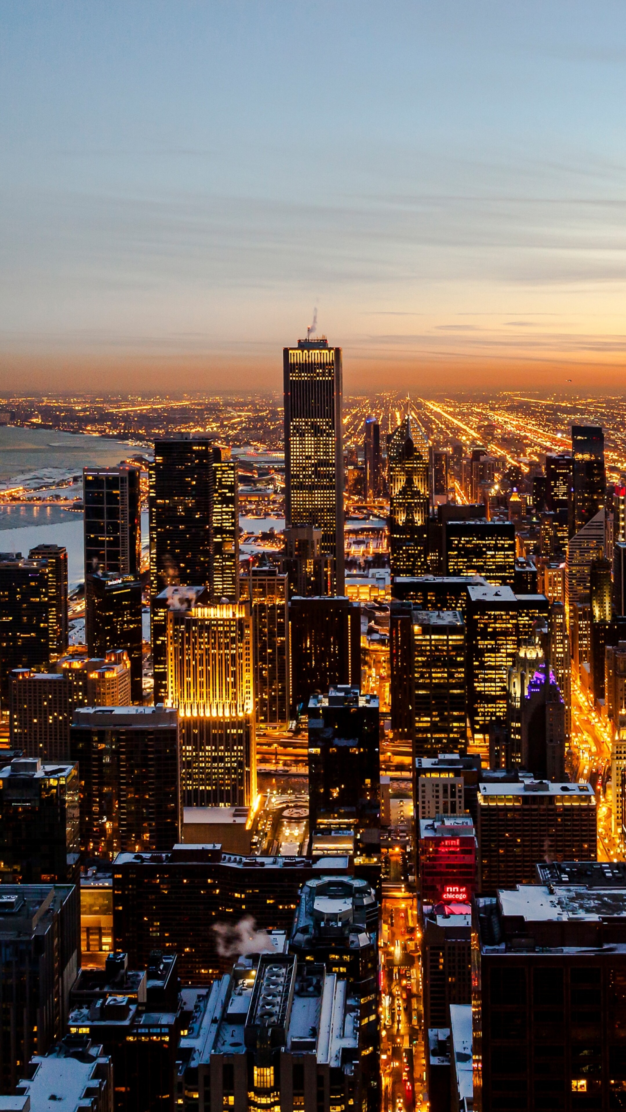 Aerial view of the Chicago downtown skyline and skyscrapers under a vibrant sunset sky.