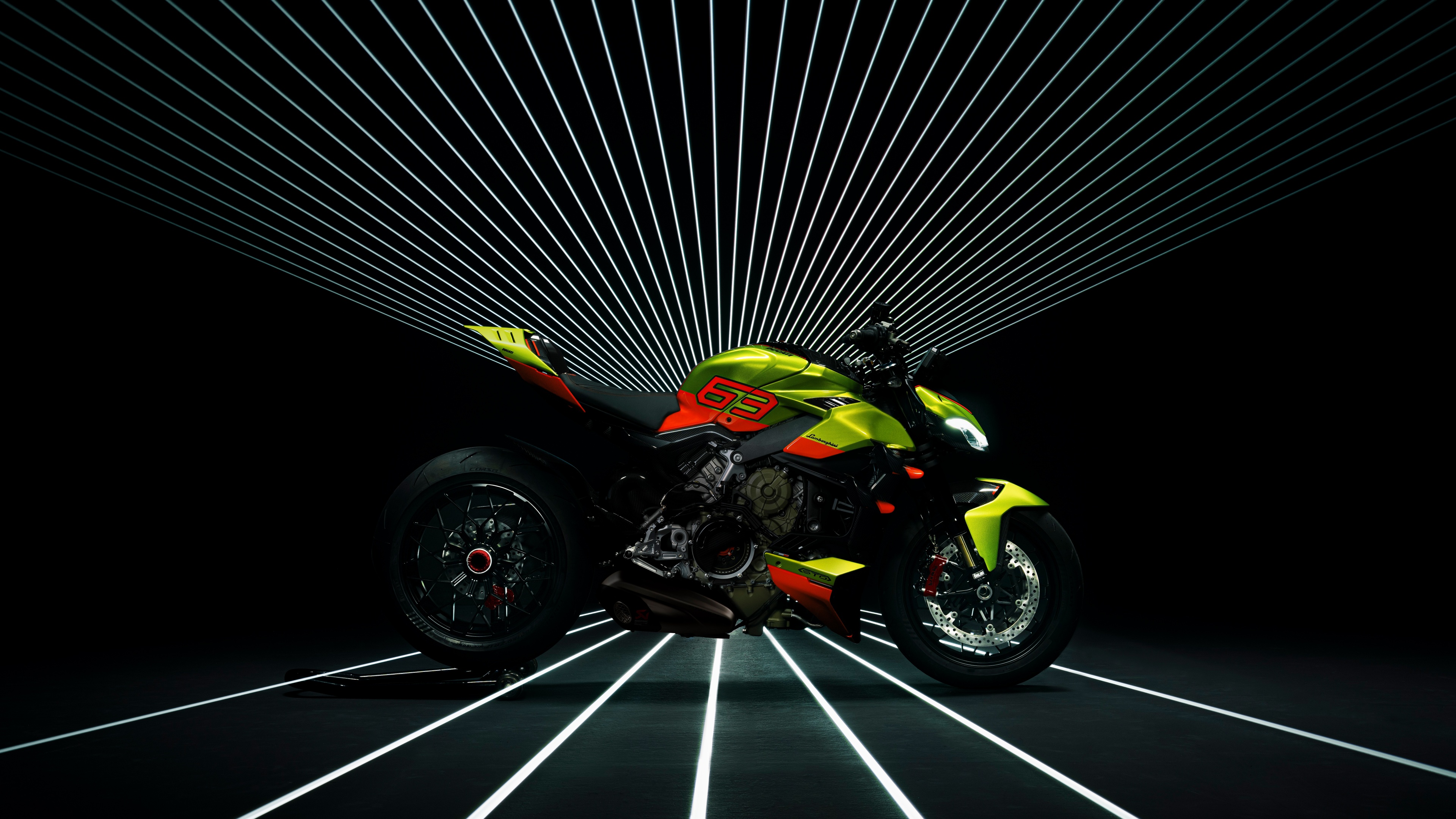 A high-detail studio shot of a Ducati Streetfighter V4 with Lamborghini-themed aesthetics and a Lamborghini Huracán STO supercar on a black background.