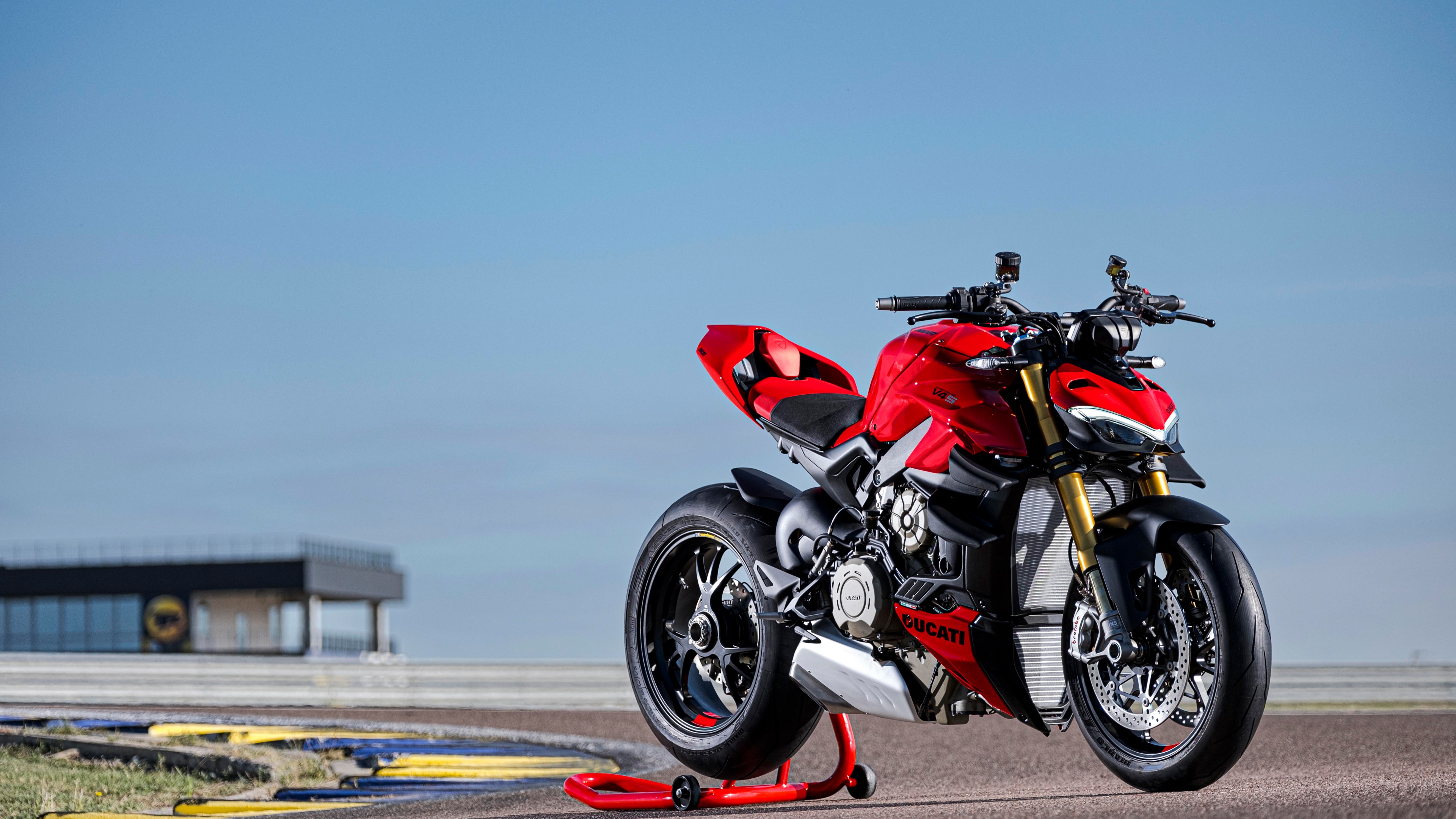 A 2023 Ducati Streetfighter V4 S sports motorcycle racing on a professional track.