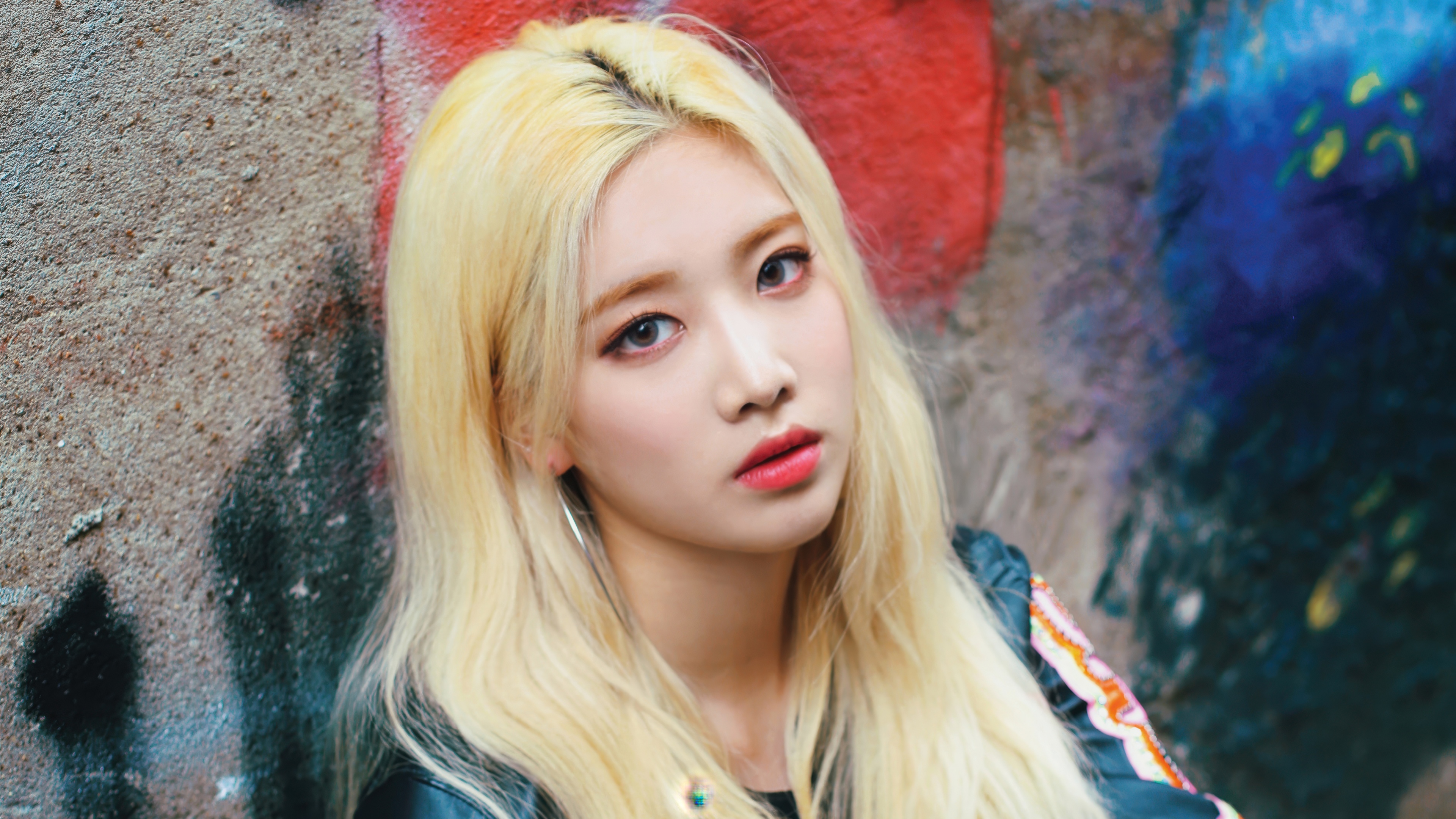 A stylishly dressed South Korean K-Pop singer looking into the camera with professional studio lighting.