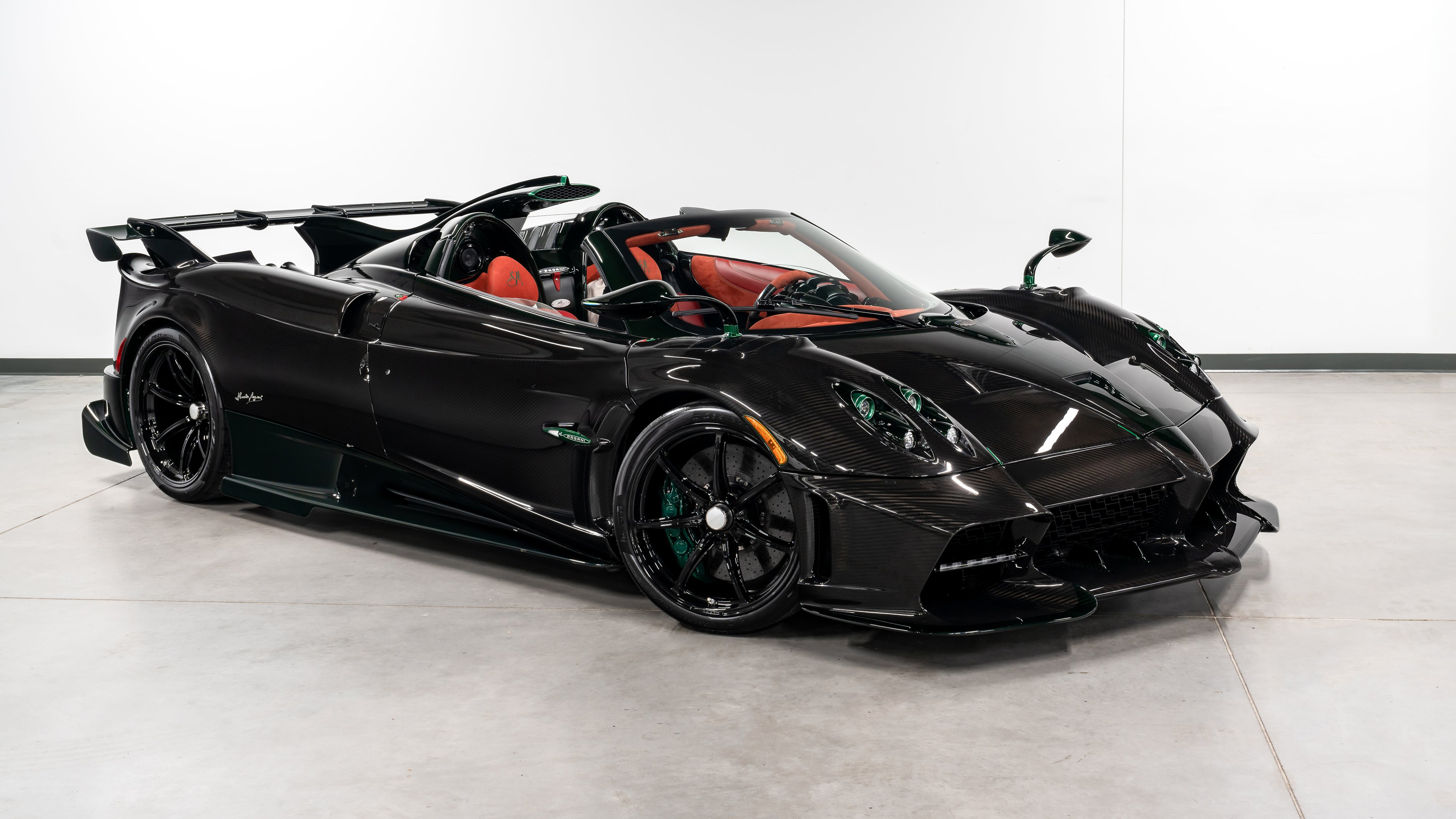 A sleek and aerodynamic 2024 Pagani Imola Roadster supercar finished in a glossy, deep black color.