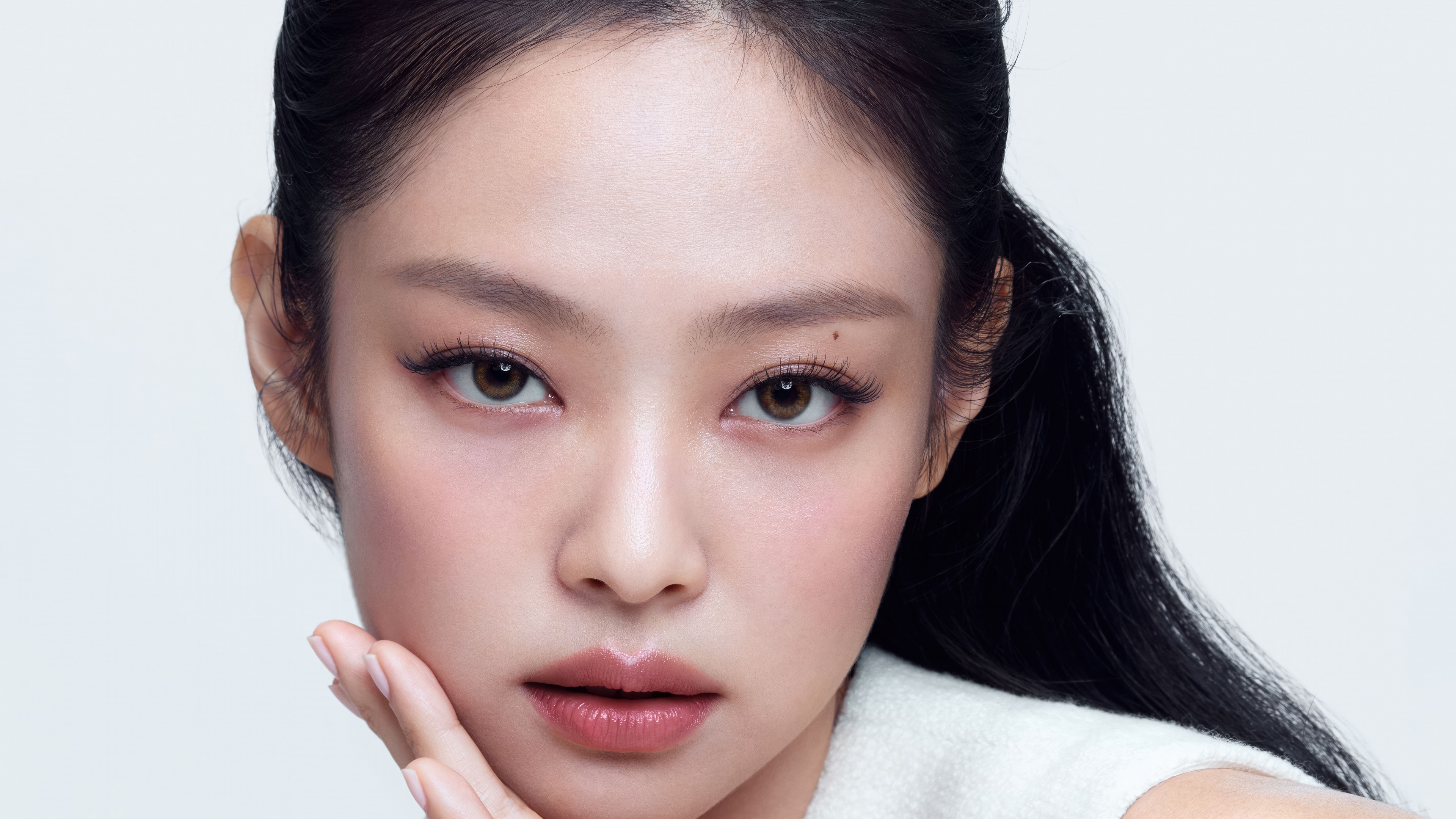 A high-resolution portrait of Jennie Kim from BLACKPINK featuring a minimalist white aesthetic and white background.