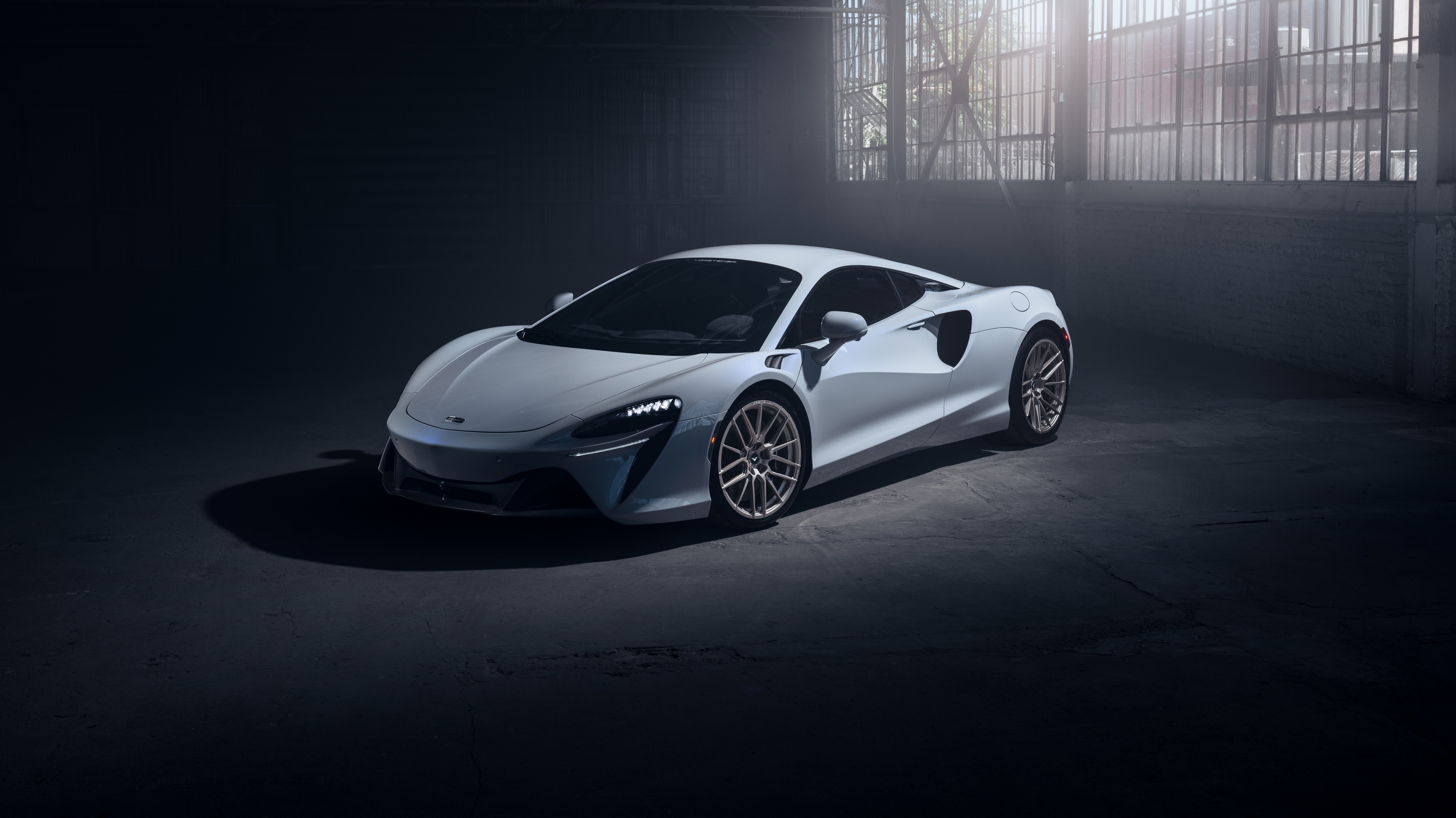 A detailed view of a 2024 McLaren Artura featuring Vorsteiner aftermarket modifications and aerodynamic styling.