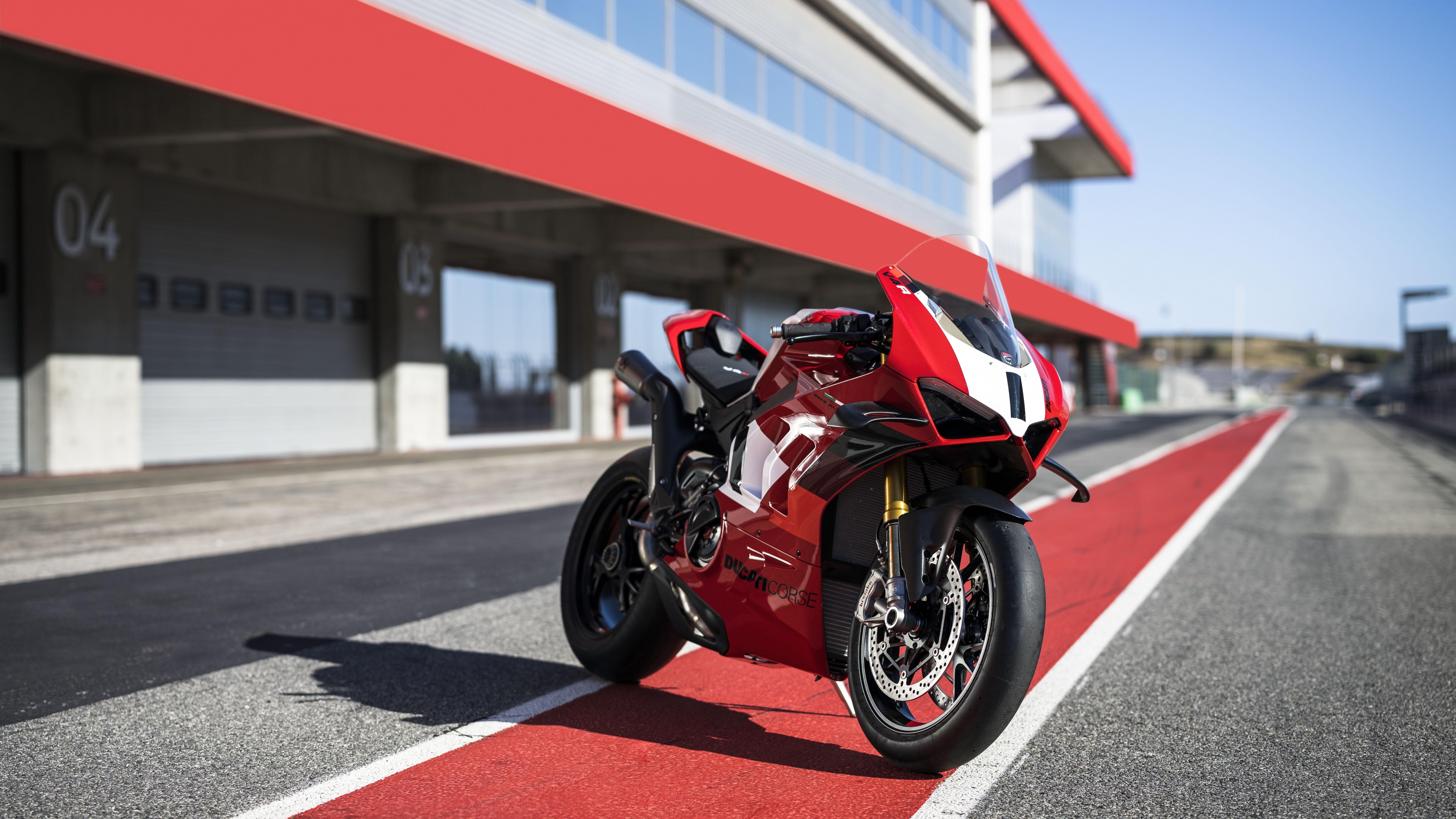 A high-resolution shot of a 2023 Ducati Panigale V4 R sports bike on a professional racing track.