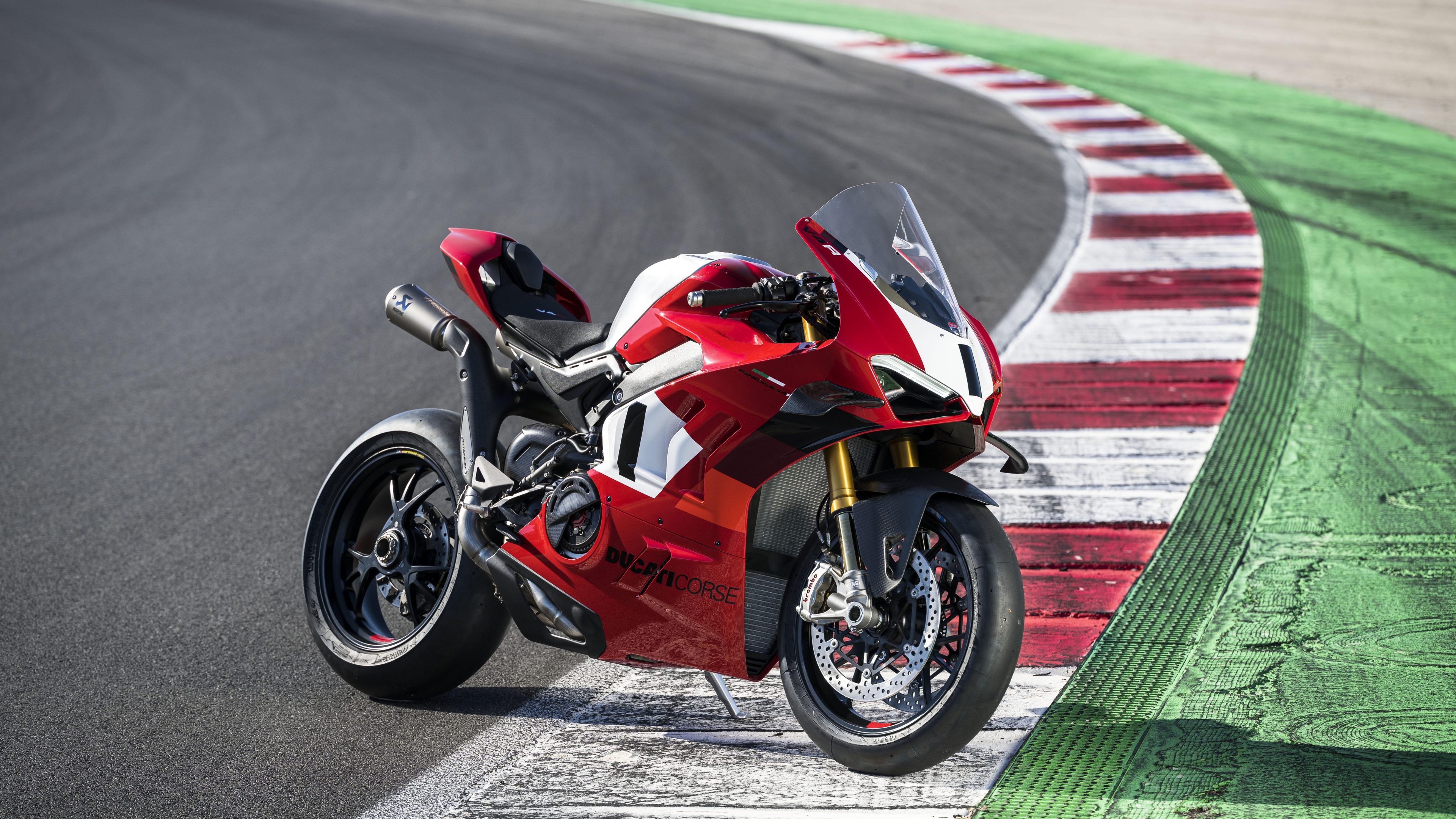 A Ducati Panigale V4 R sports motorcycle speeding on a professional race track.