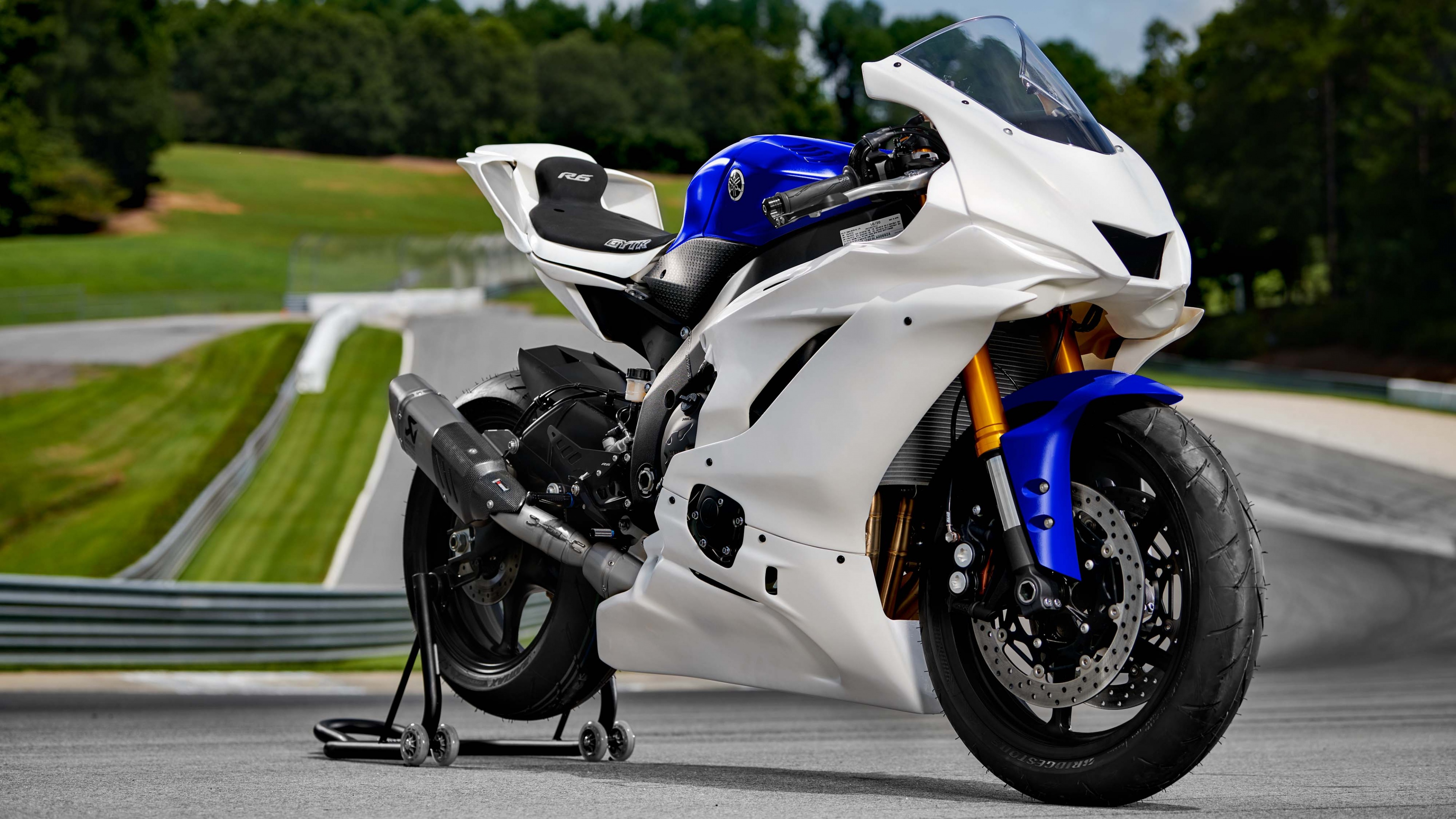 A close-up view of a modern, brightly colored sports motorcycle with aerodynamic design and sleek metallic finishes.