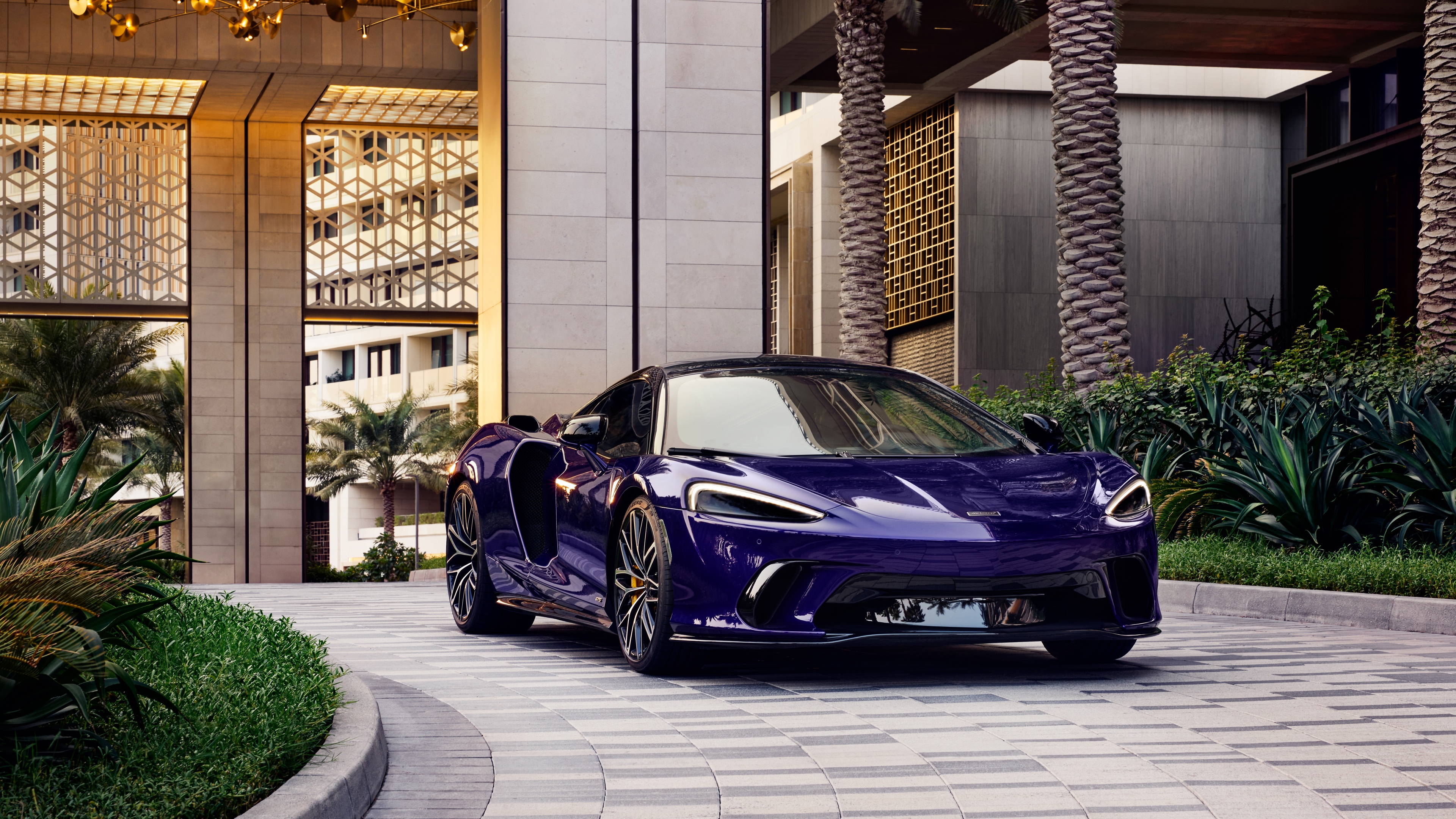 A high-performance 2024 McLaren GTS supercar parked in a scenic outdoor landscape during daylight.