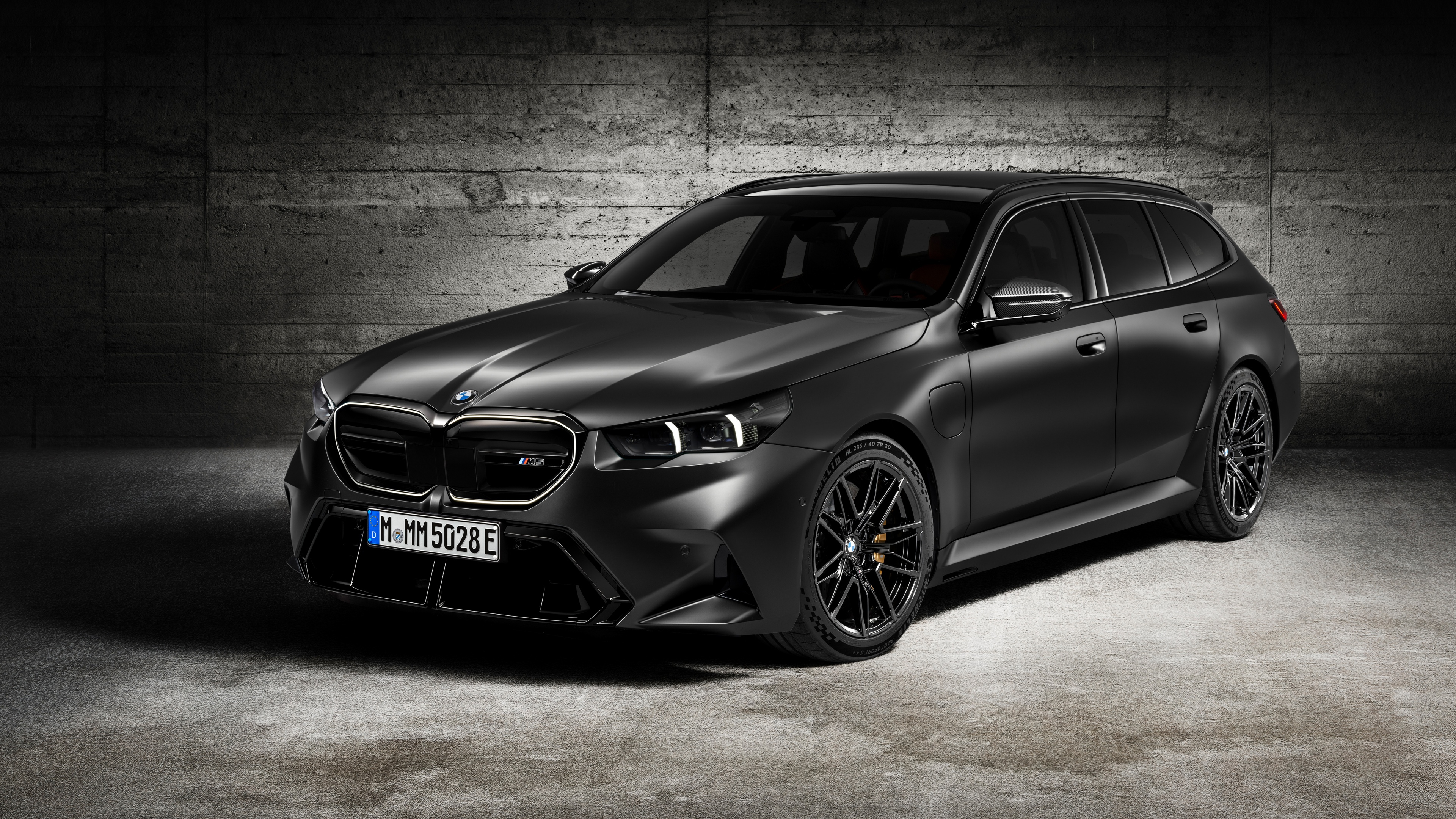 A high-resolution close-up of a sleek black 2024 BMW M5 luxury performance sedan.