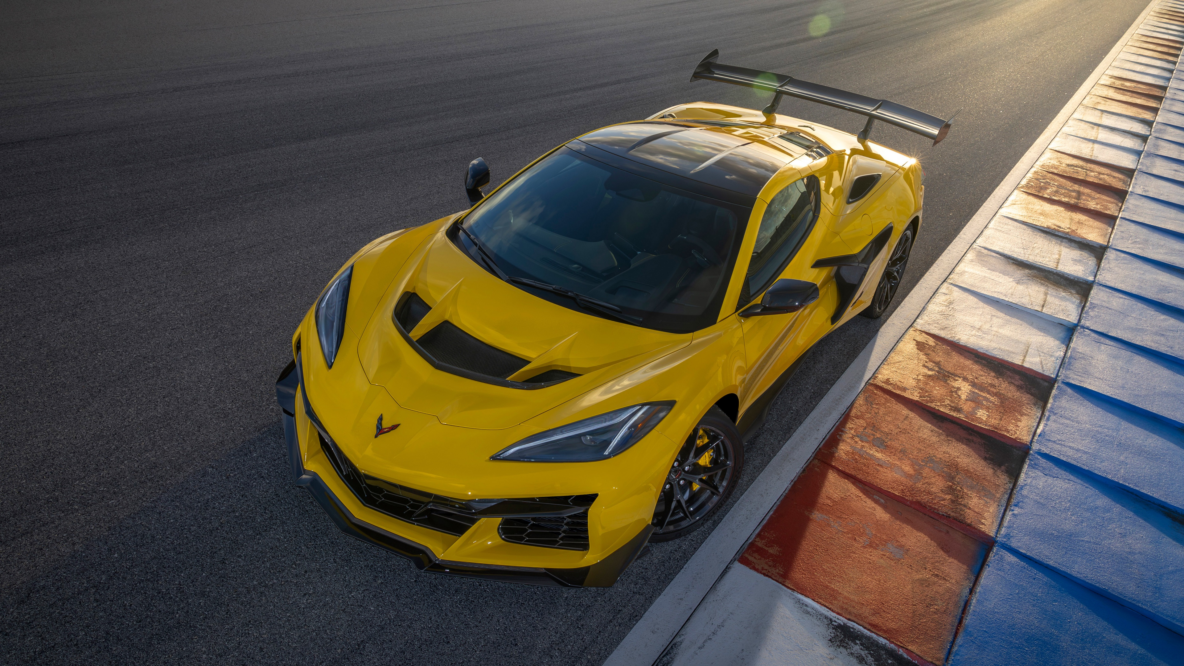A sleek 2025 Chevrolet Corvette ZR1 driving at high speed on a professional race track.