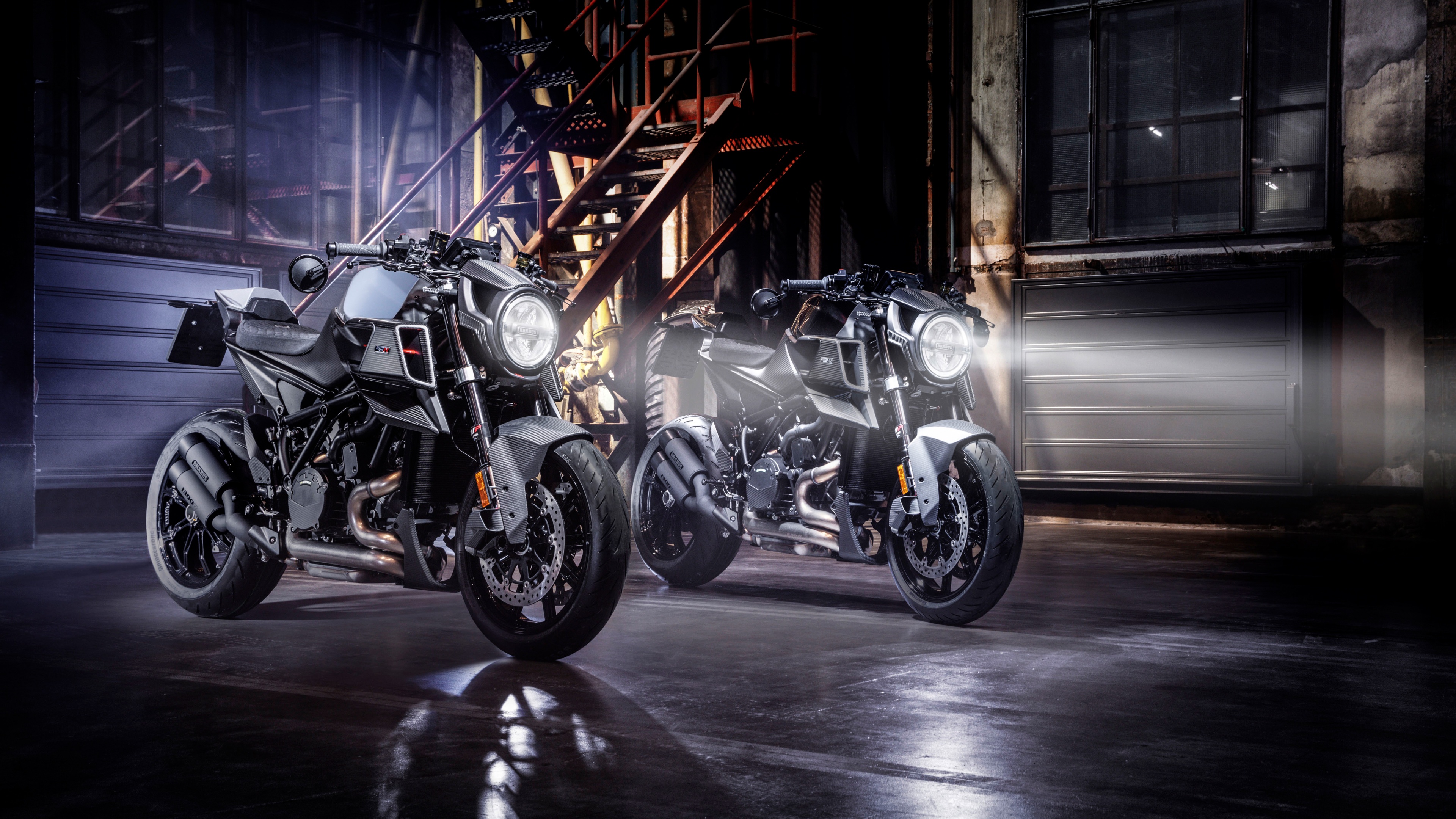 A high-detail cinematic shot featuring the Brabus 1300 R Edition 23 and the KTM 1290 Super Duke R EVO naked bikes against a dark background.