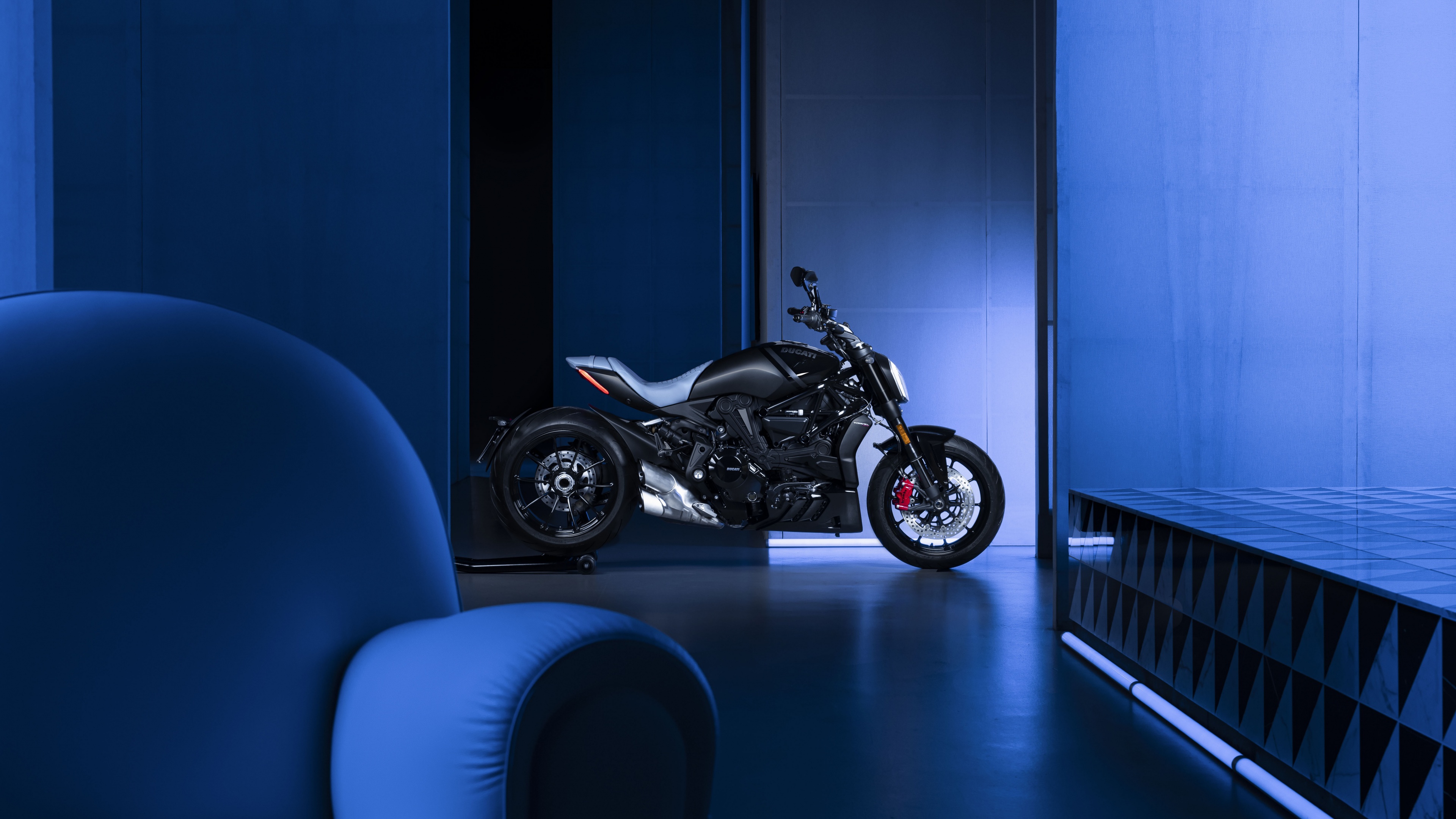 A 2022 Ducati XDiavel Nera limited edition sports cruiser motorcycle presented against a solid blue background.