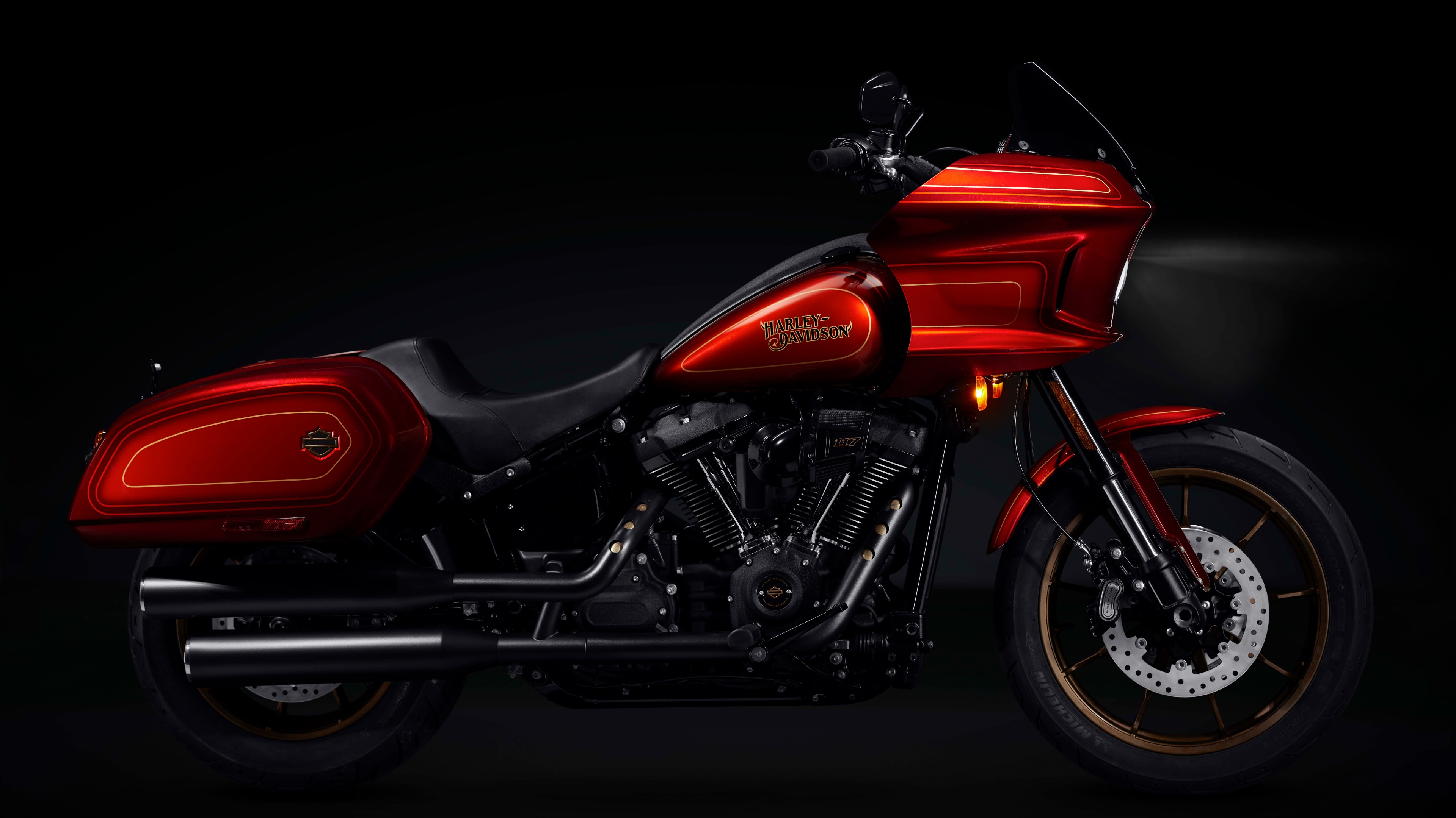 A high-resolution, dark-themed close-up of the Harley-Davidson Low Rider El Diablo motorcycle with intense lighting and a deep black background.