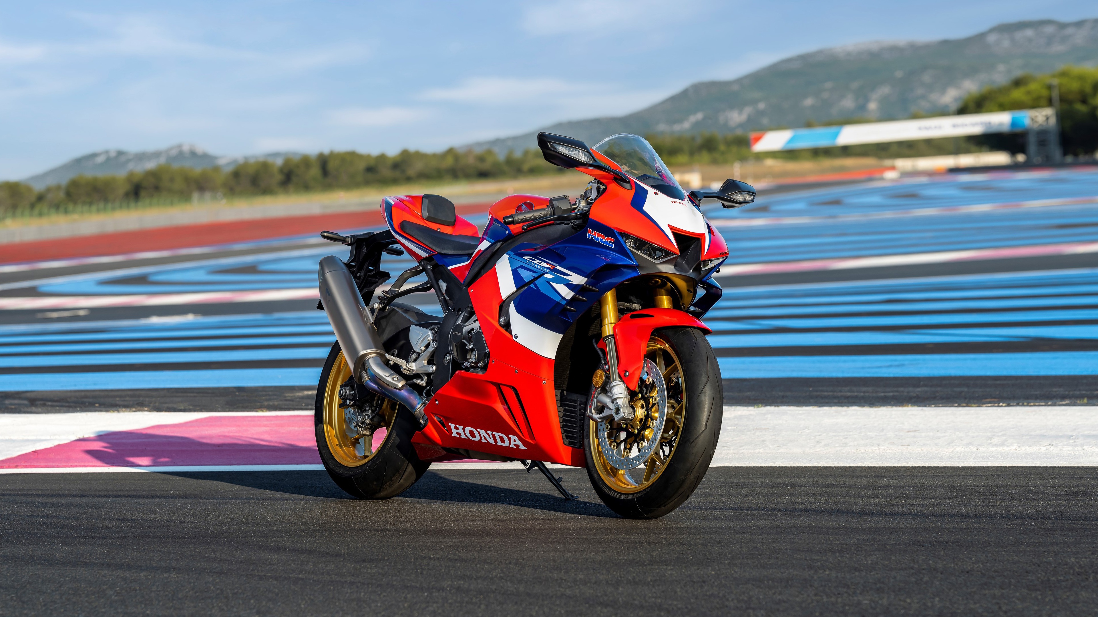 A 2022 Honda CBR1000RR-R Fireblade SP sports motorcycle speeding on a professional race track.