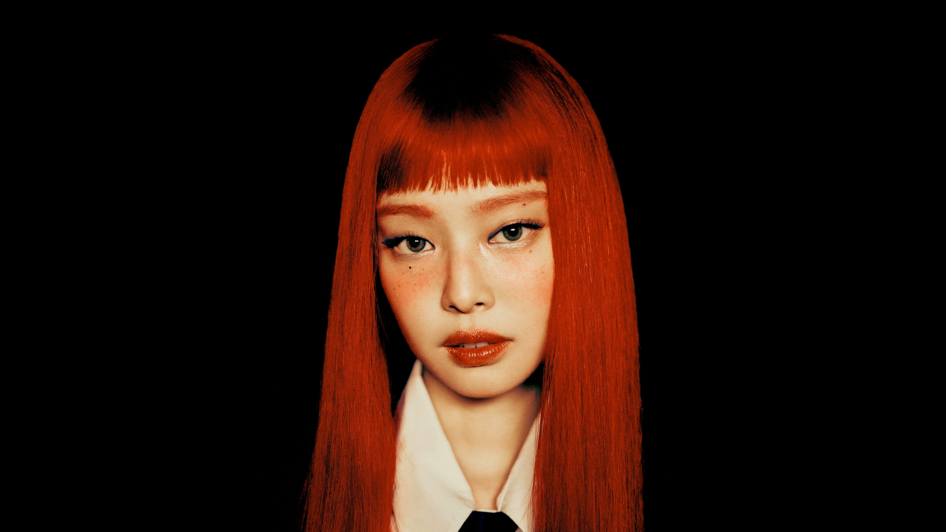 A high-contrast, vibrant ruby red portrait of Jennie Kim from BLACKPINK set against a solid black background.