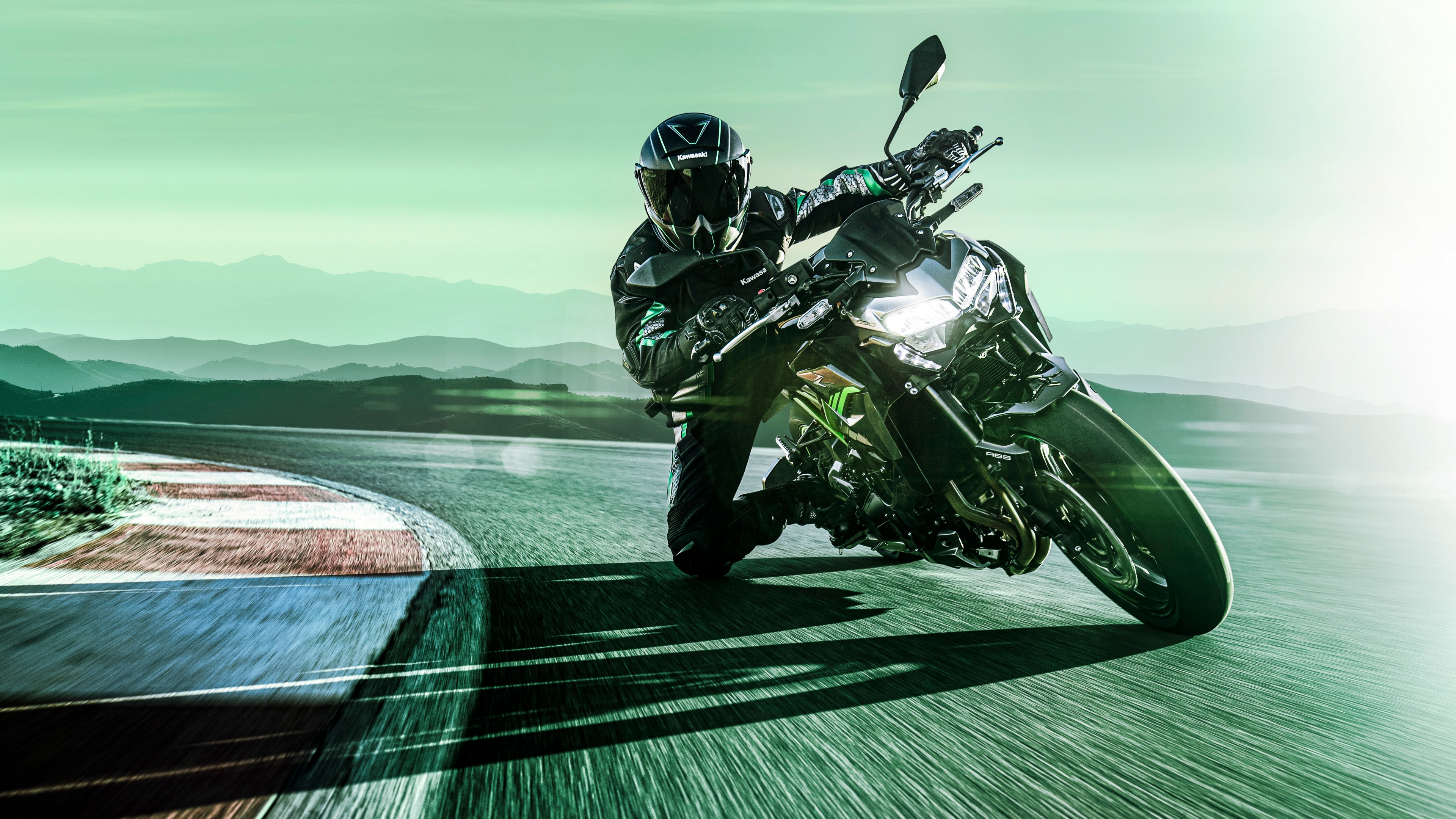 A 2023 Kawasaki Z900 sports motorcycle speeding on a race track.
