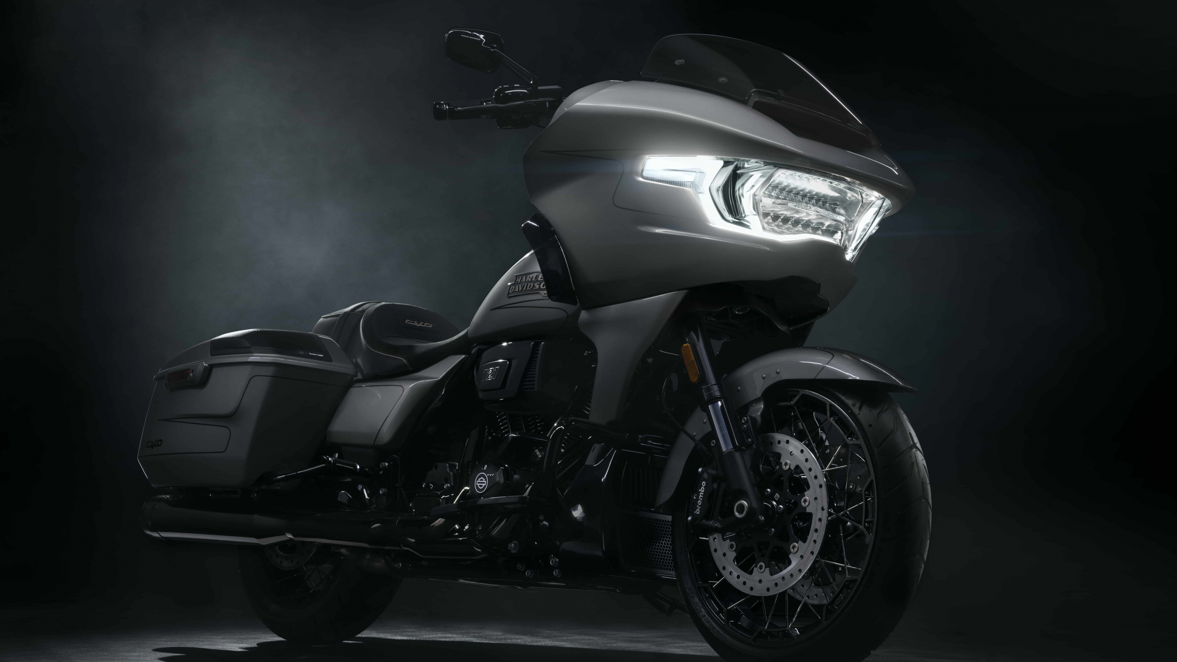 A detailed cruiser motorcycle with polished chrome elements on a dark, moody background.