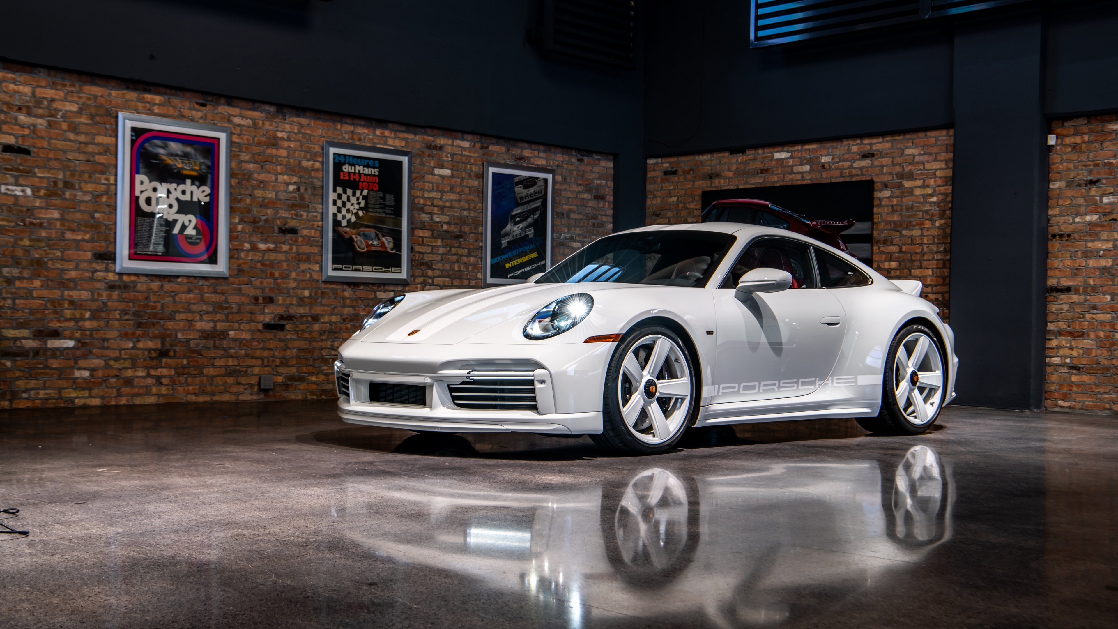 A detailed view of the 2024 Porsche 911 Sport Classic featuring its signature rear ducktail spoiler and classic automotive styling.