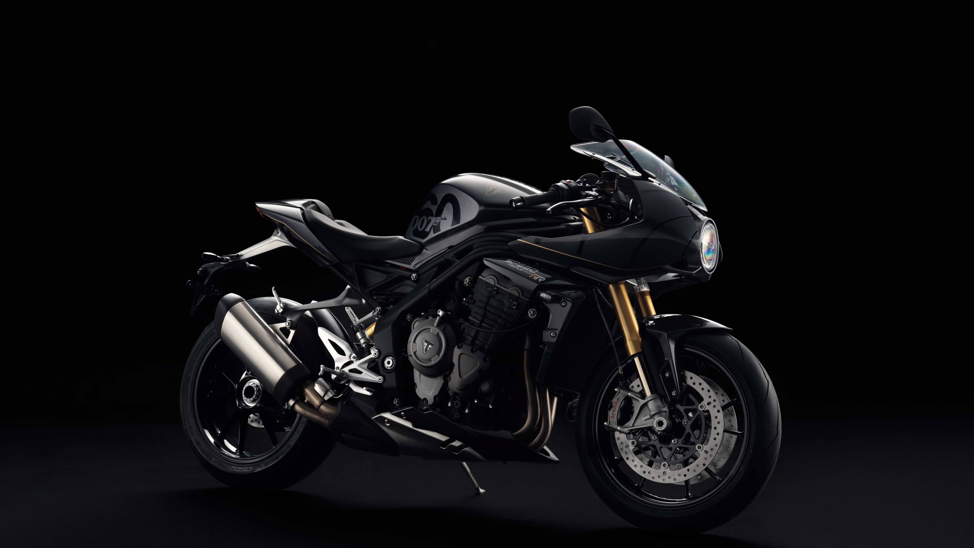 Close-up high-definition shot of the Triumph Speed Triple 1200 RR Bond Edition motorcycle against a dark, minimalist background.