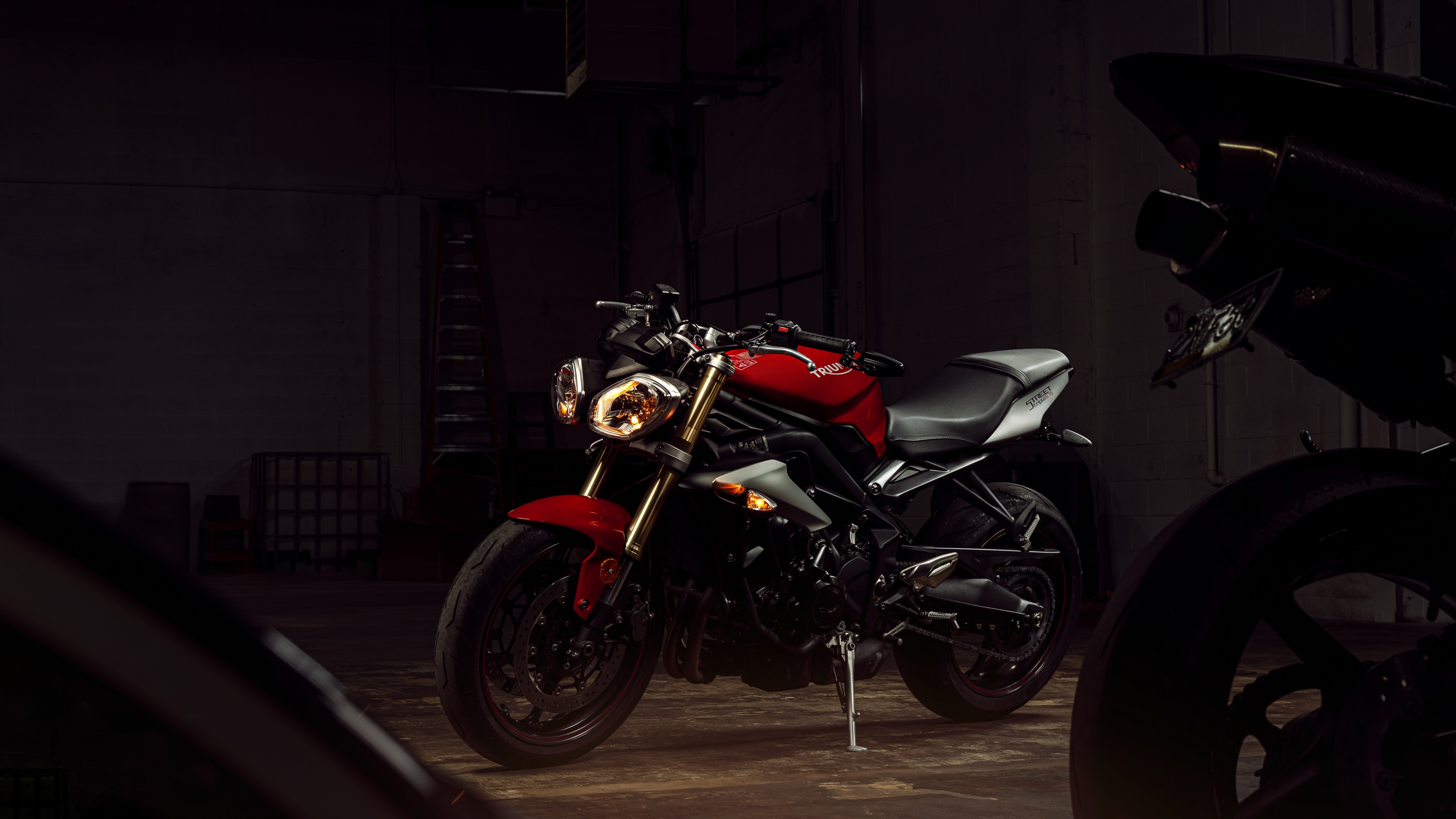 High-resolution close-up of a Triumph Street Triple streetfighter motorcycle showcasing detailed engine and frame components.