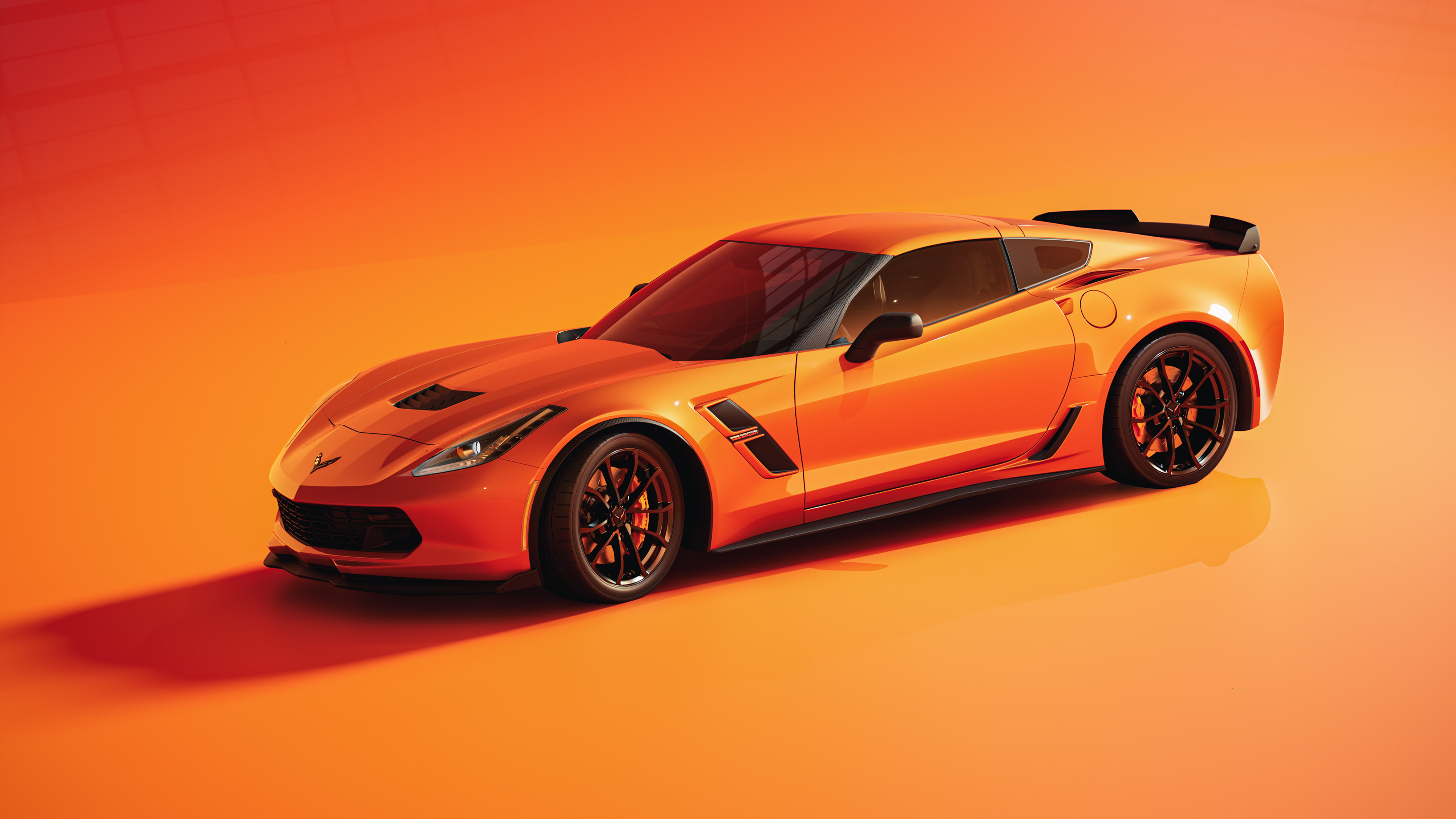 A sleek Chevrolet Corvette sports car set against a vibrant orange background.