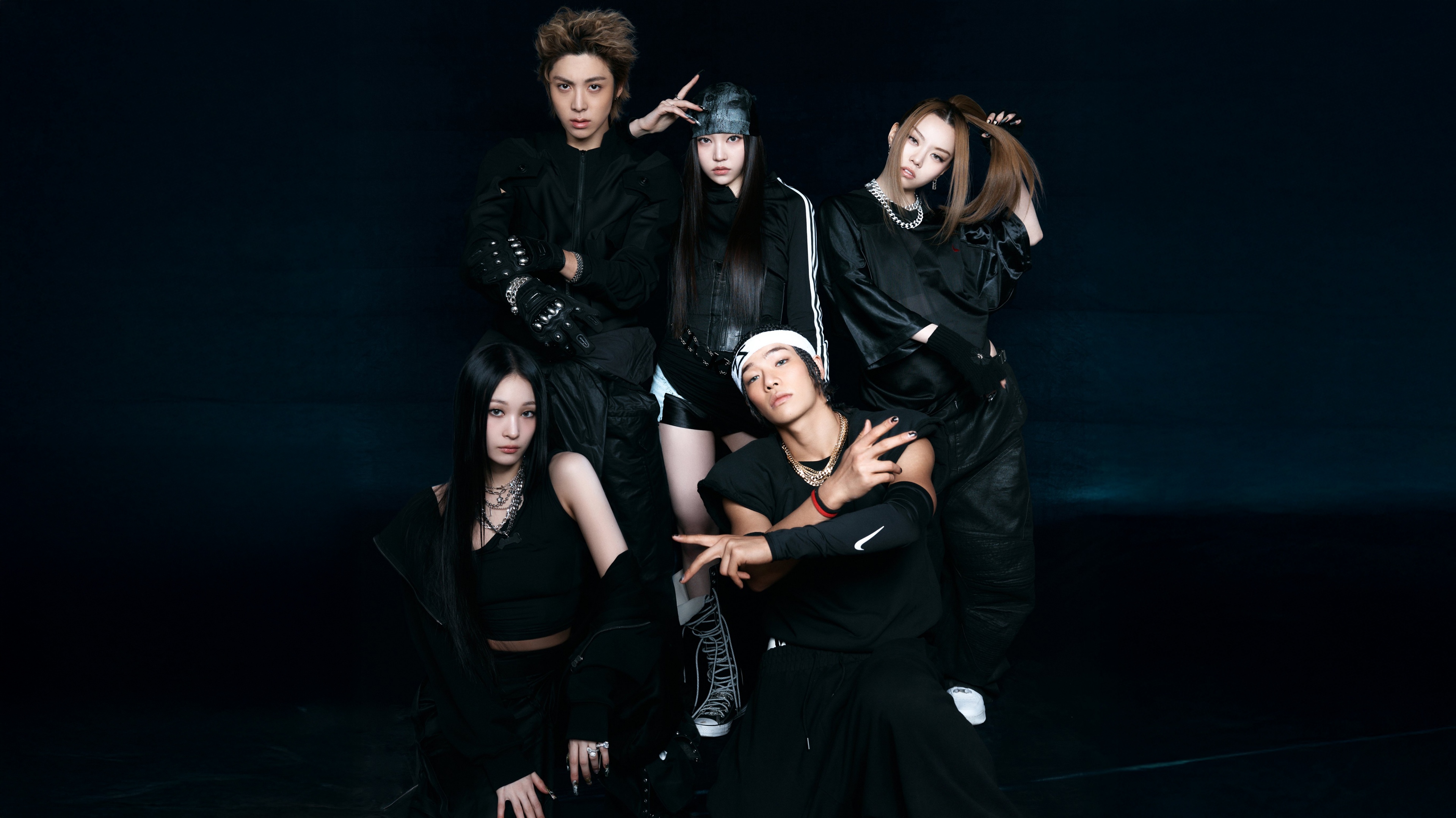 A group portrait of K-pop idols Youngseo, Annie, Bailey, Tarzzan, and Woochan from the group ALLDAY PROJECT, set against a dark, moody background.