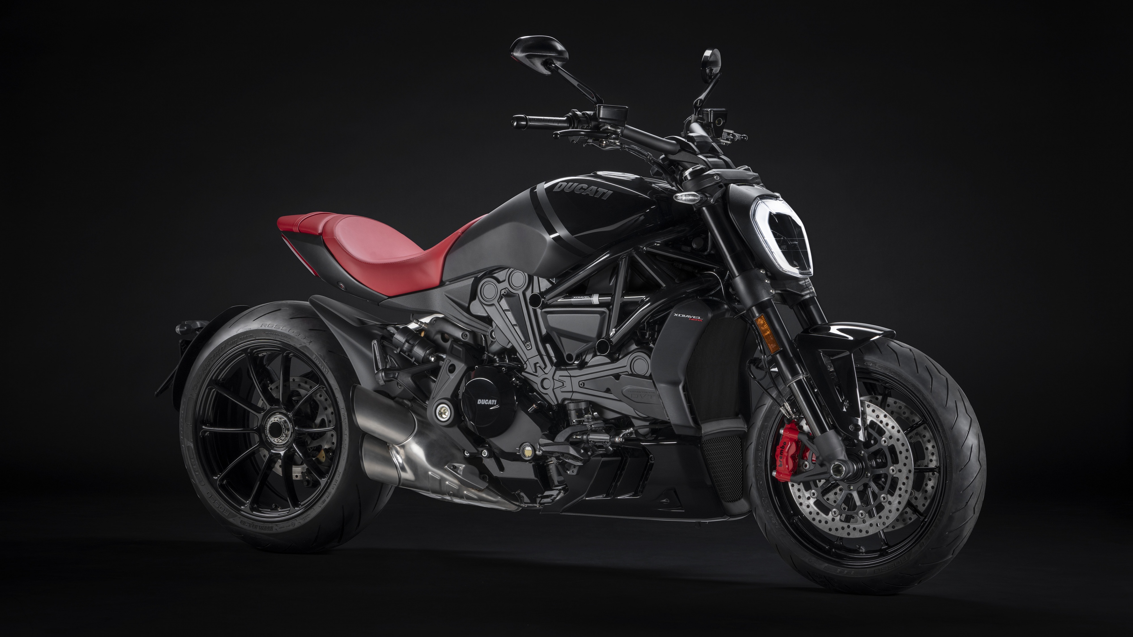 A sleek, black 2022 Ducati XDiavel Nera sports cruiser motorcycle against a dark, minimalist background.