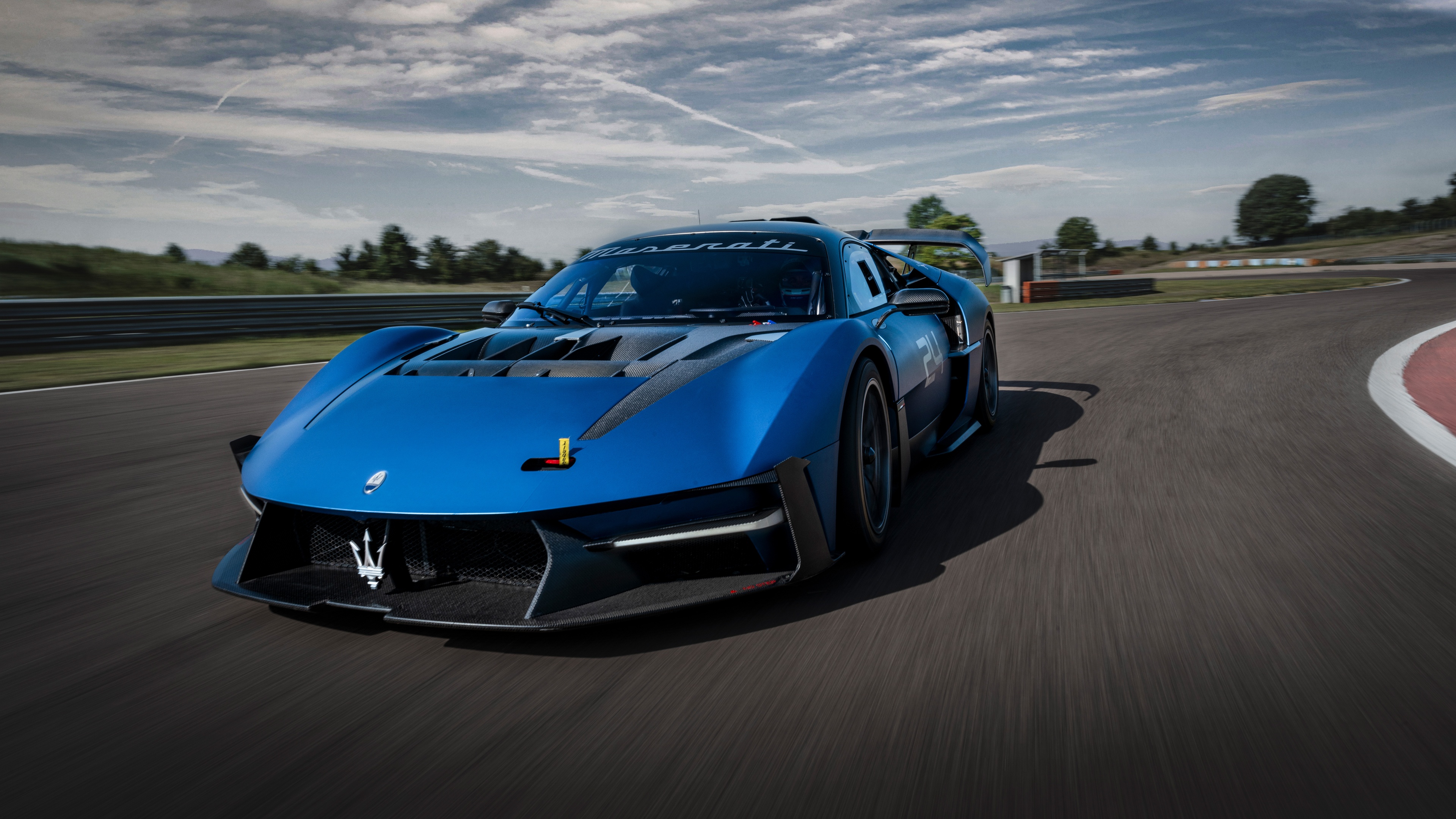 A Maserati MCXtrema supercar speeding along a professional race track curve.