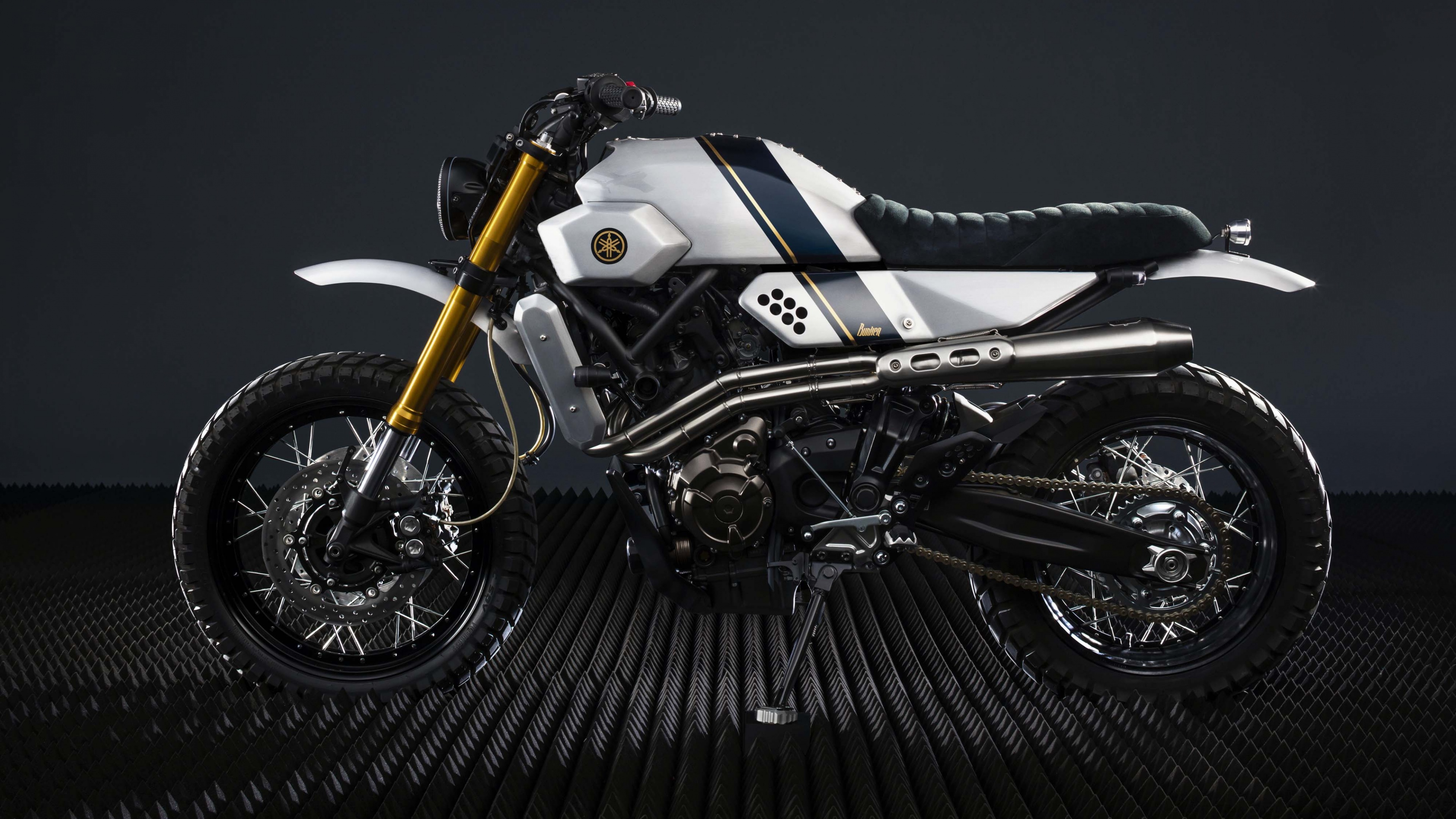 A high-end custom motorcycle with chrome details on a dark, atmospheric background.