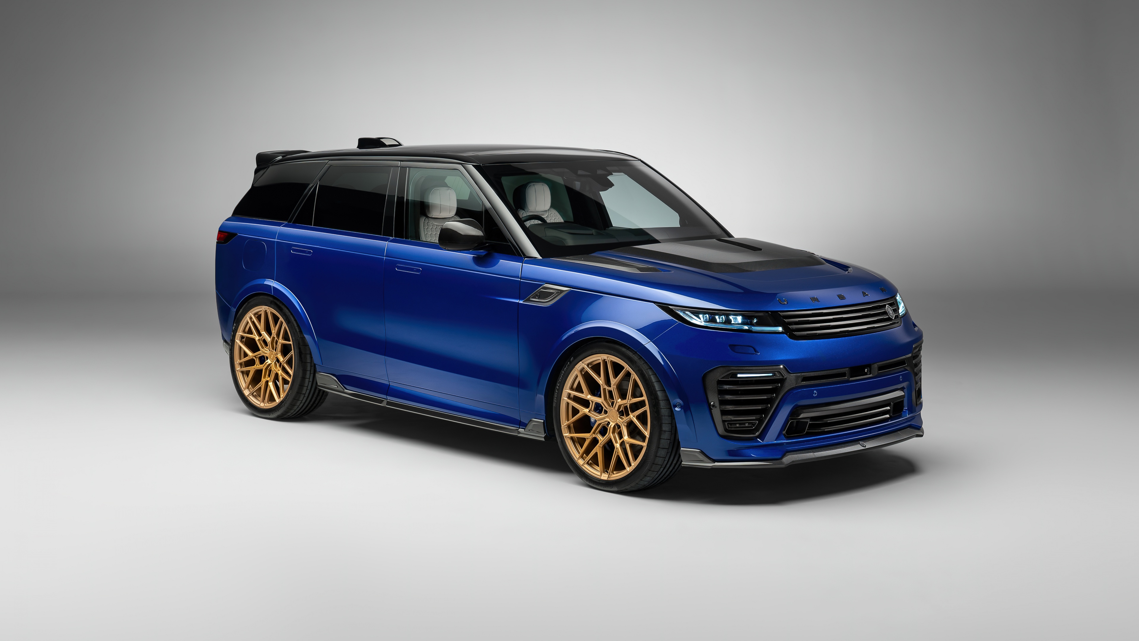 A high-resolution, cinematic shot of a 2024 Range Rover Sport navigating through a modern metropolitan cityscape.