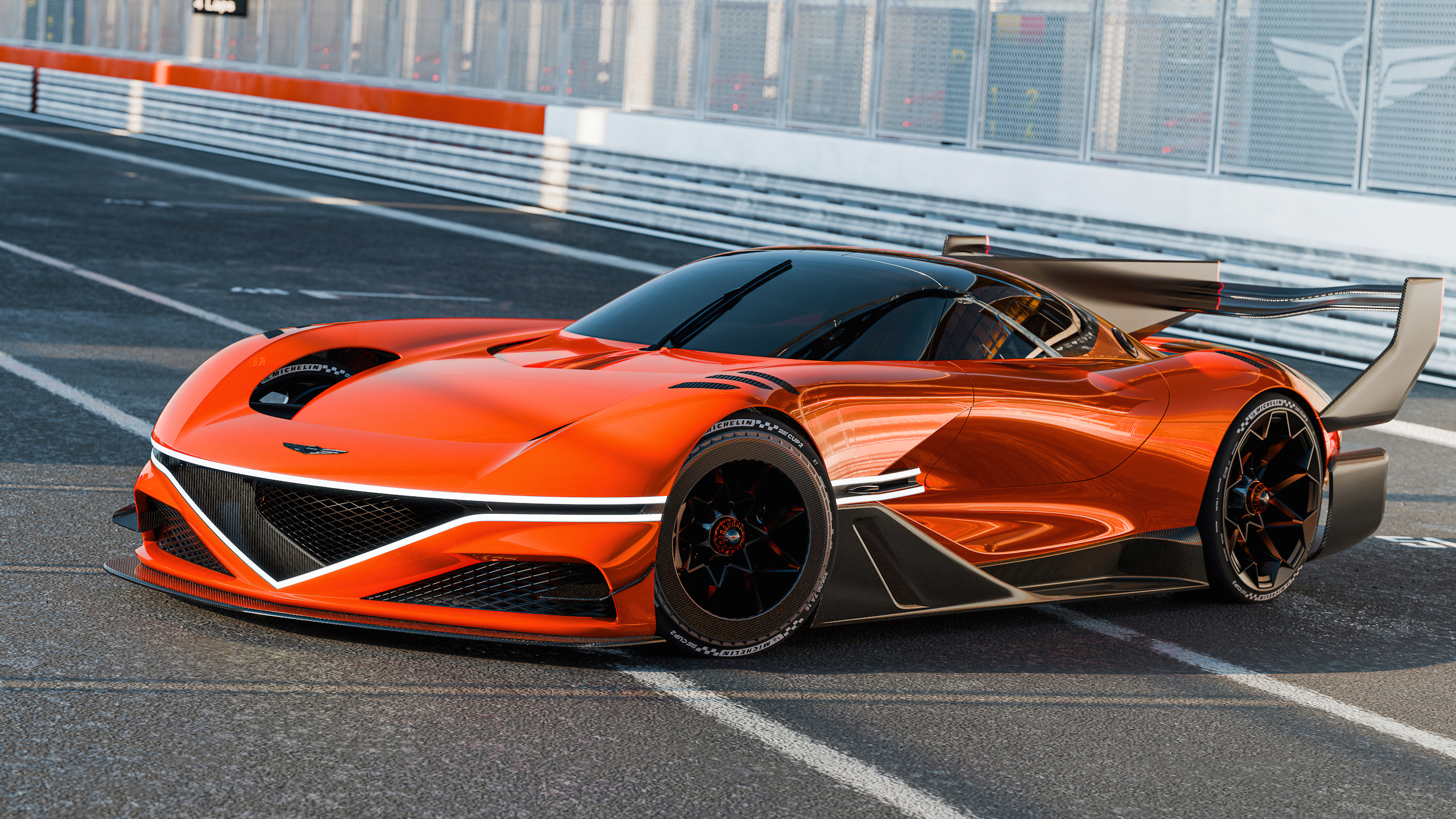 The Genesis X Concept car driving through a sharp turn on a modern professional race track.