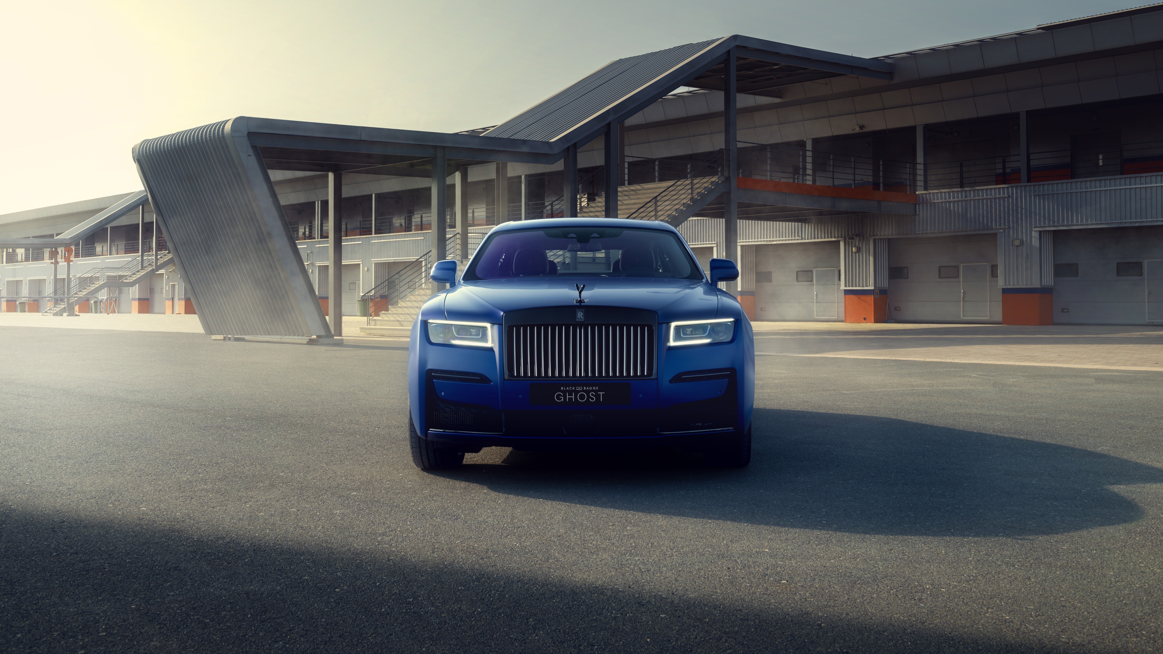 A high-detail, cinematic view of a polished black Rolls-Royce Black Badge Ghost featuring a dark, aesthetic finish.