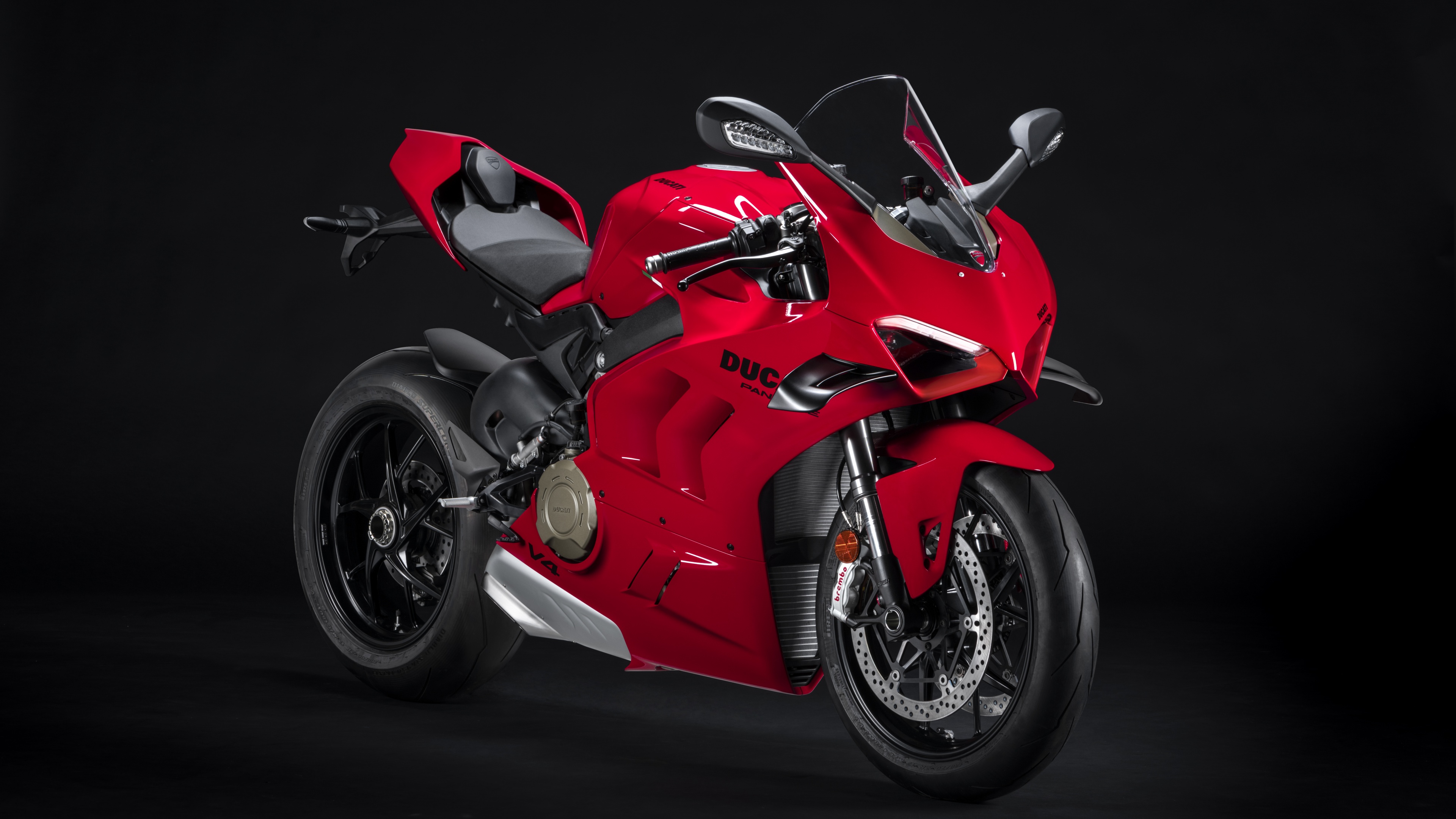 A high-resolution close-up of a red 2022 Ducati Panigale V4 sports bike presented against a dark, dramatic background.