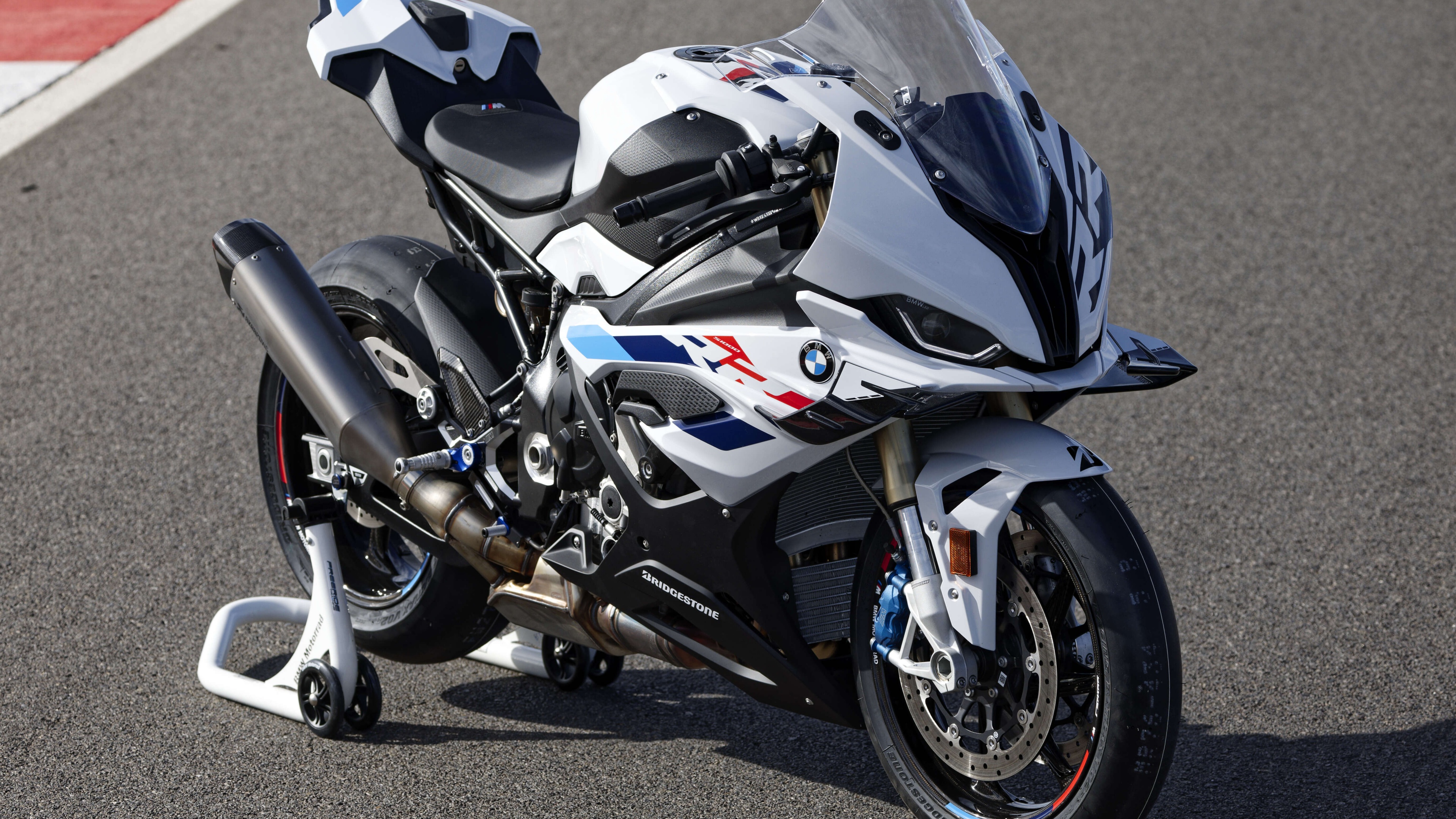 A sleek and aerodynamic 2023 BMW S 1000 RR racing motorcycle in a professional display.
