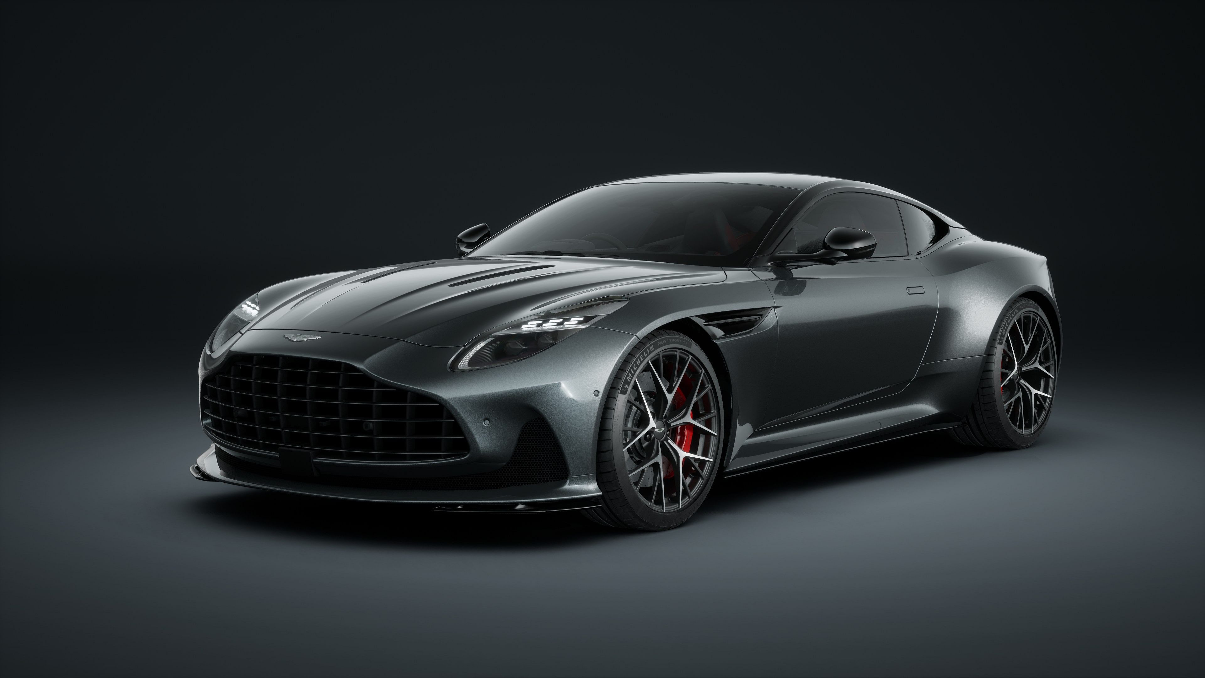 A high-end Aston Martin DB12 sports car captured in a dark, atmospheric setting, emphasizing its sleek metallic body and luxurious design.