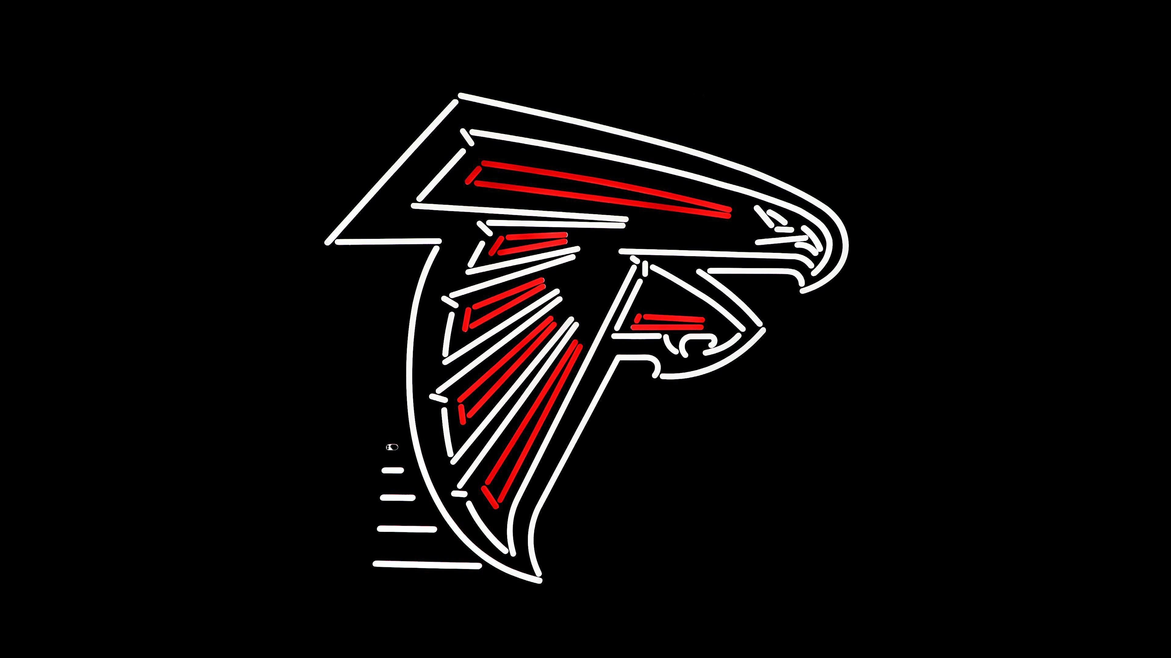 Atlanta Falcons NFL logo with bright neon LED lighting on a pitch-black background.