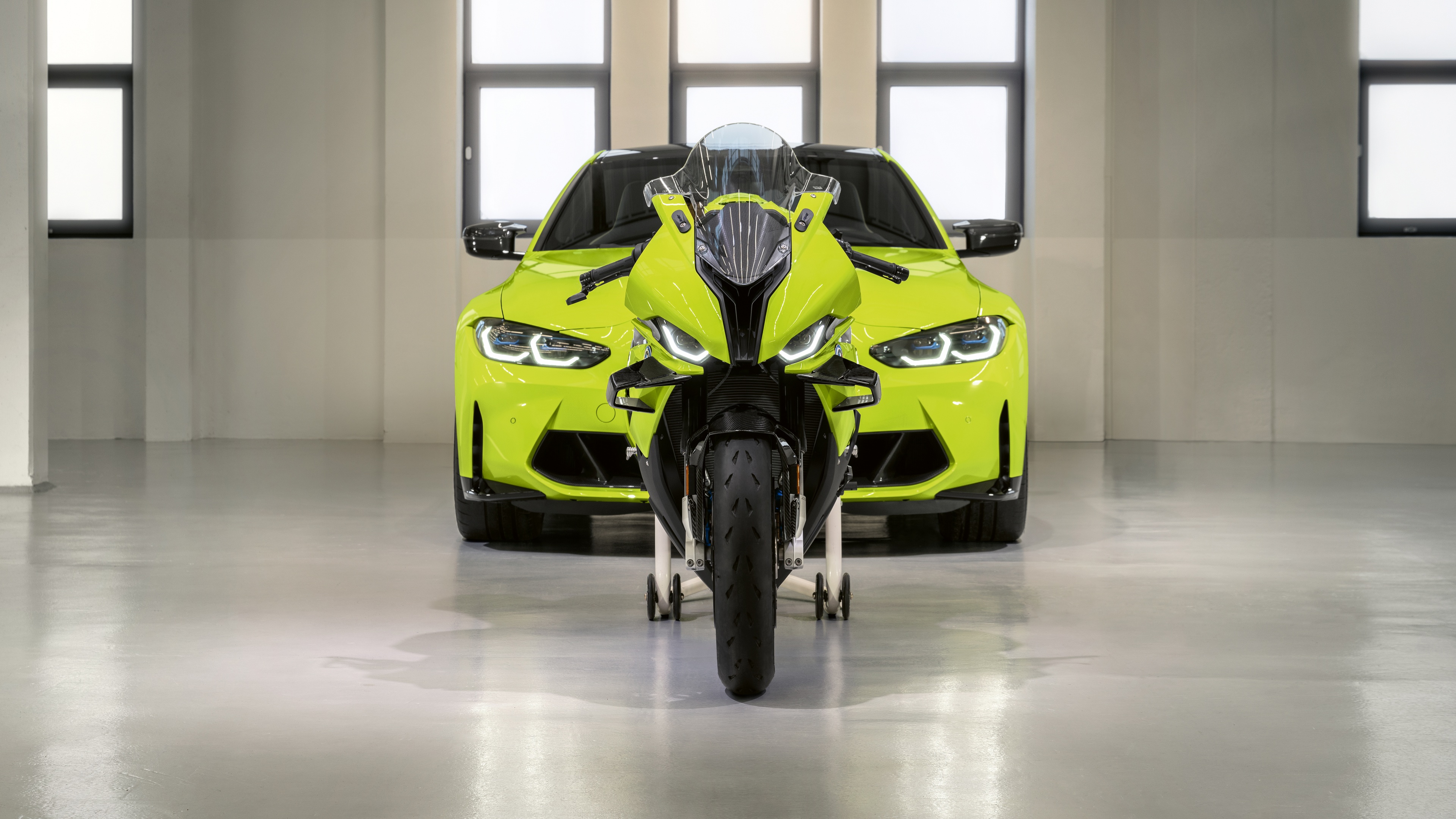 A high-detail composition featuring the BMW M 1000 RR motorcycle and the BMW M4 car, commemorating the 50th Anniversary of BMW M.