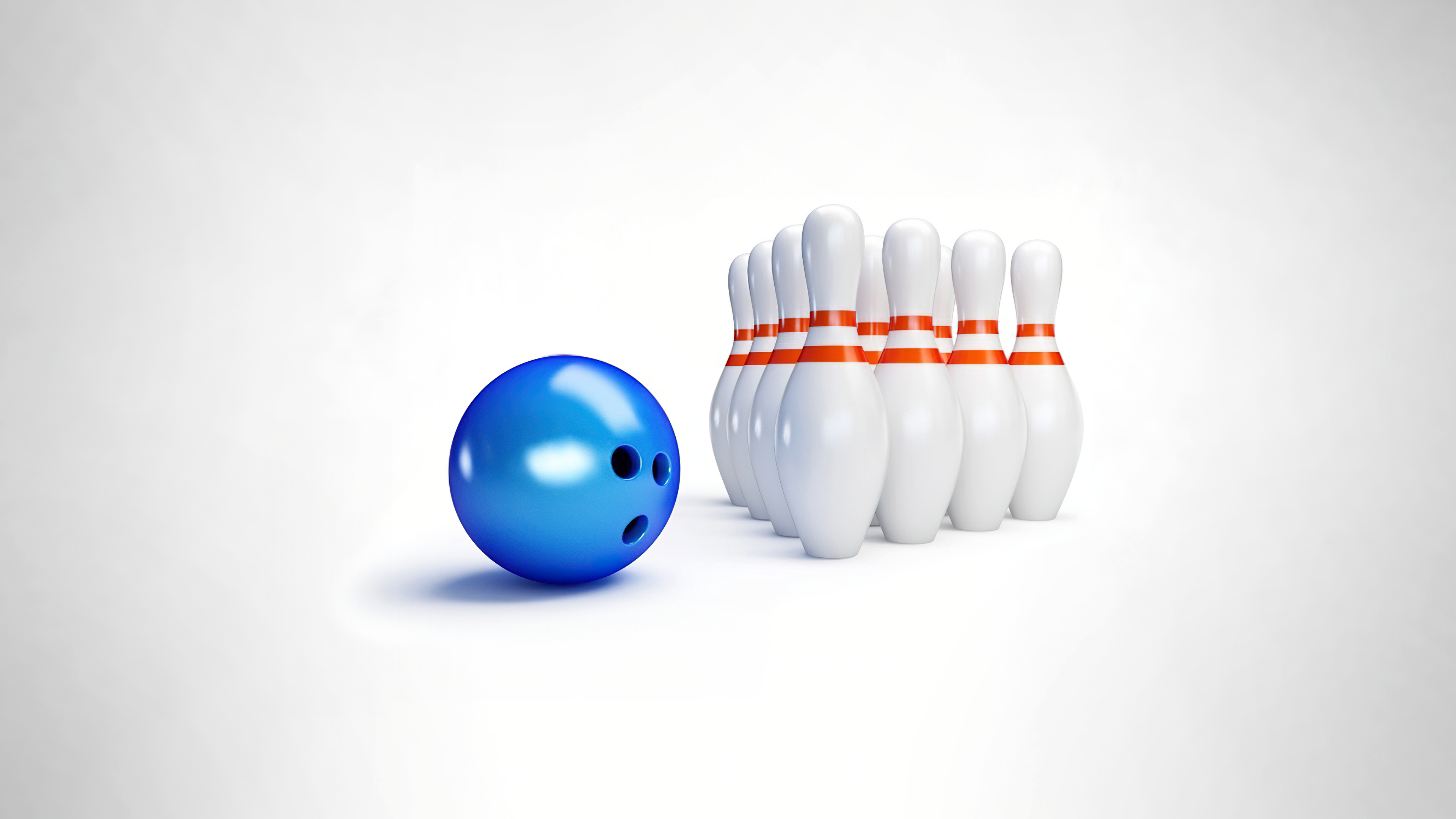 A bowling ball and set of bowling pins isolated on a plain white background.