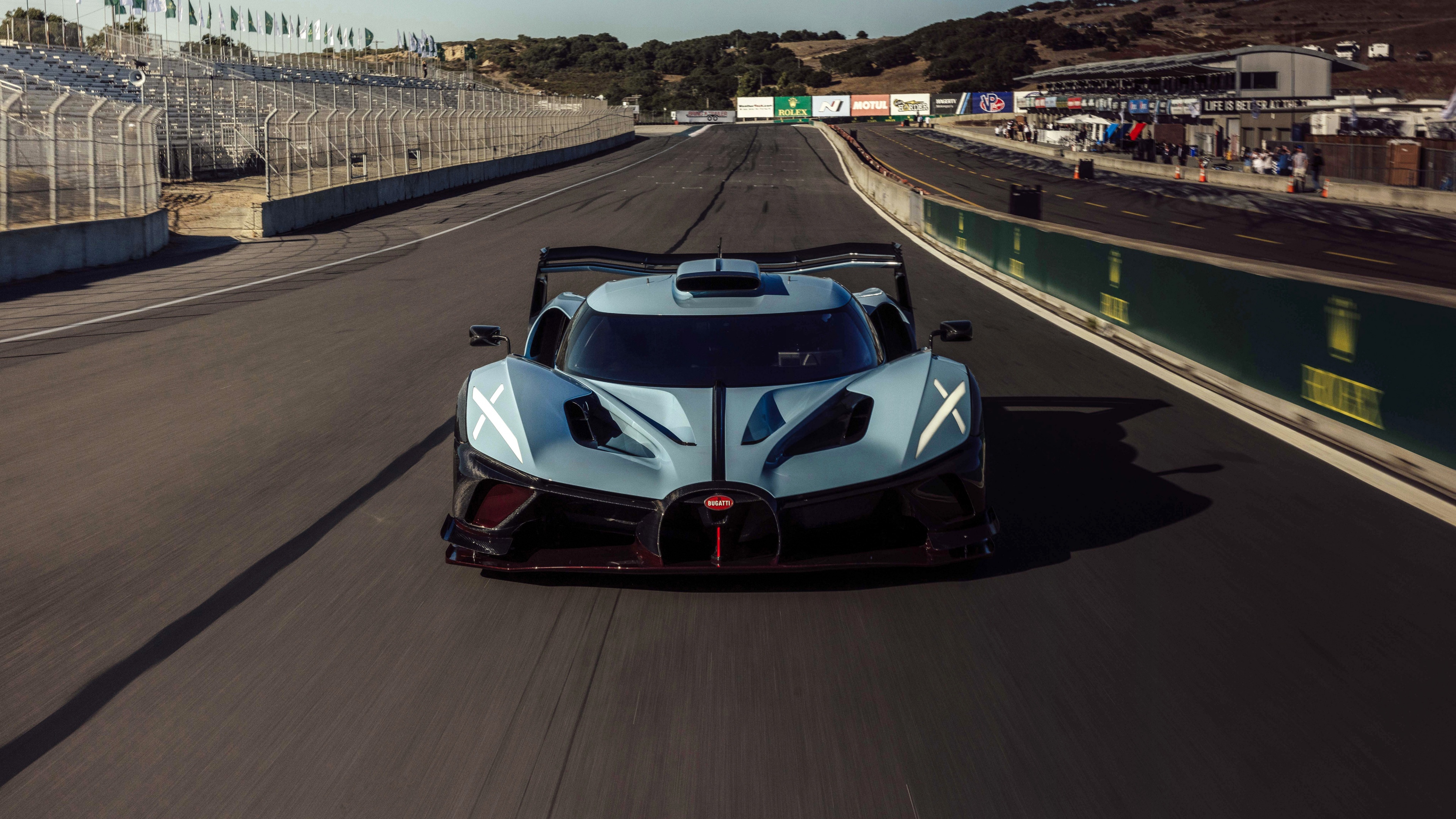 The 2024 Bugatti Bolide Anniversary Edition hypercar speeding along a professional racing circuit.
