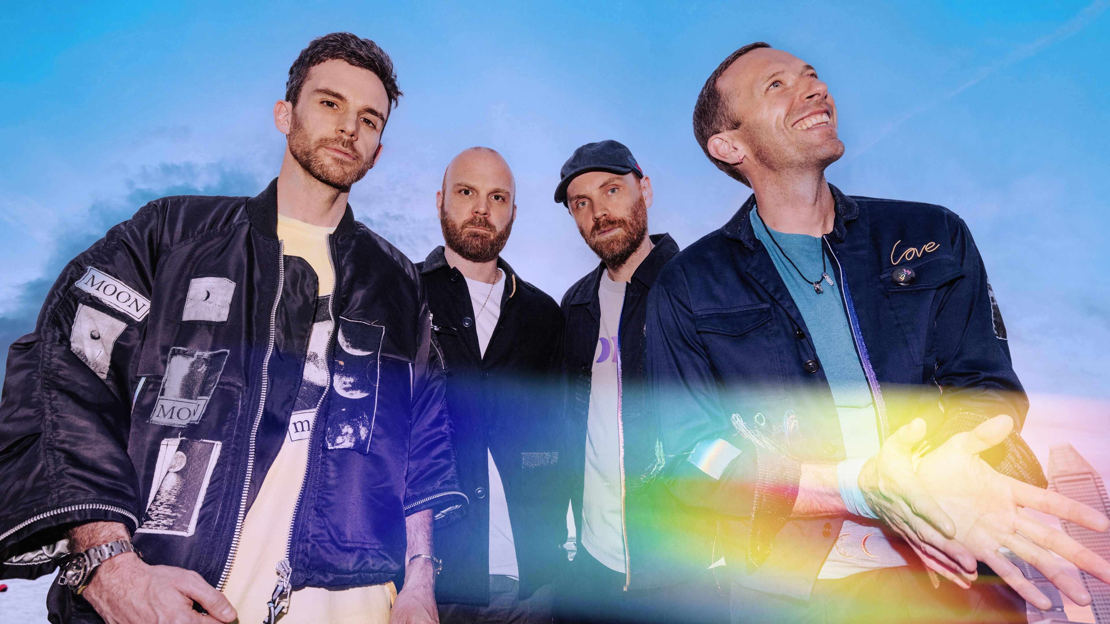 A high-detail 8K cinematic portrait of the rock band Coldplay, featuring members Chris Martin, Jonny Buckland, Guy Berryman, and Will Champion.